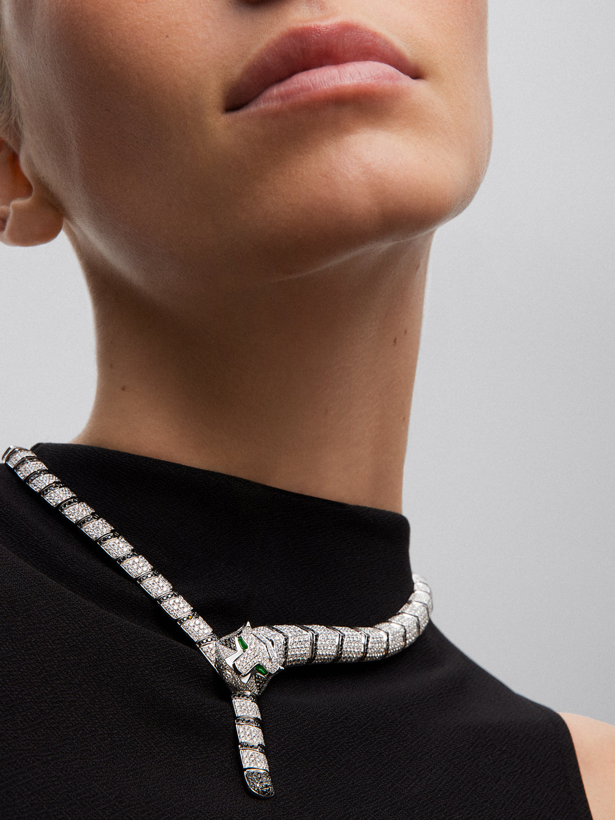 Collar rígido con forma de tigre de oro blanco de 18K con diamantes blancos y negros en talla brillante con un total de 22,7 cts y 2 esmeraldas en talla trapecio con un total de 0,13 cts