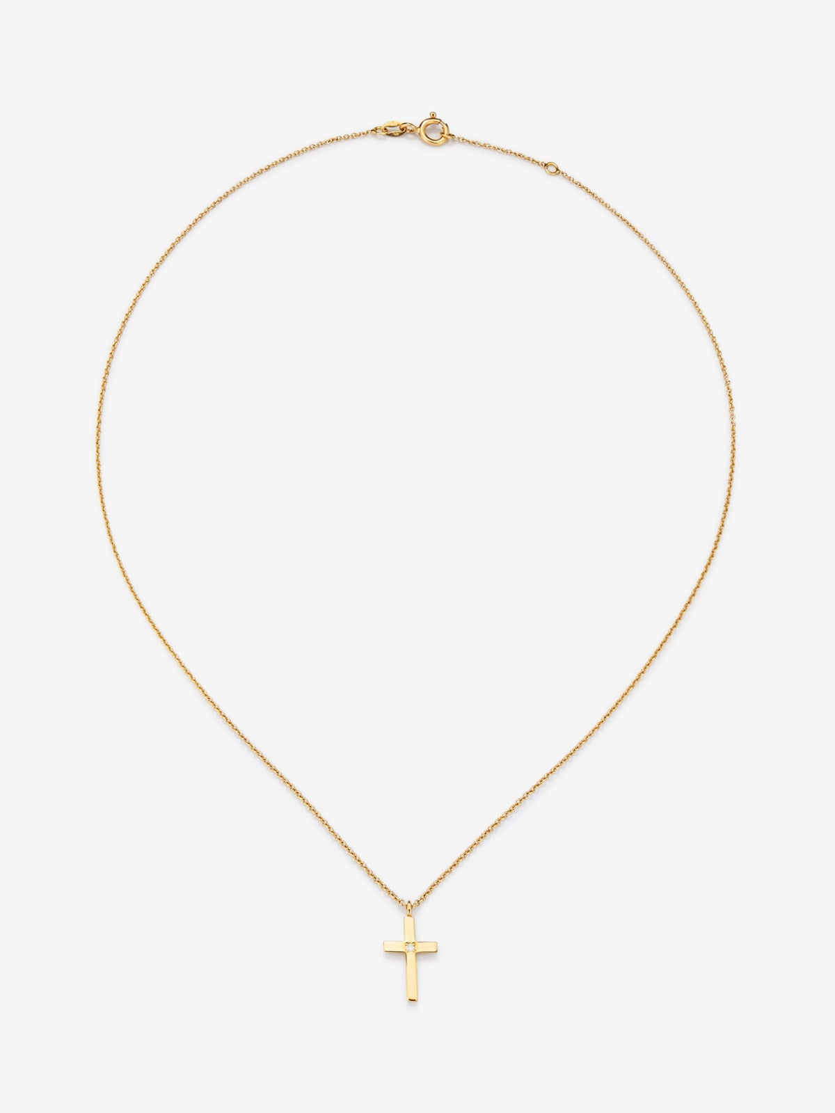 Colgante de oro amarillo de 18K con cruz mediana y diamante en talla brillante de 0,01 cts