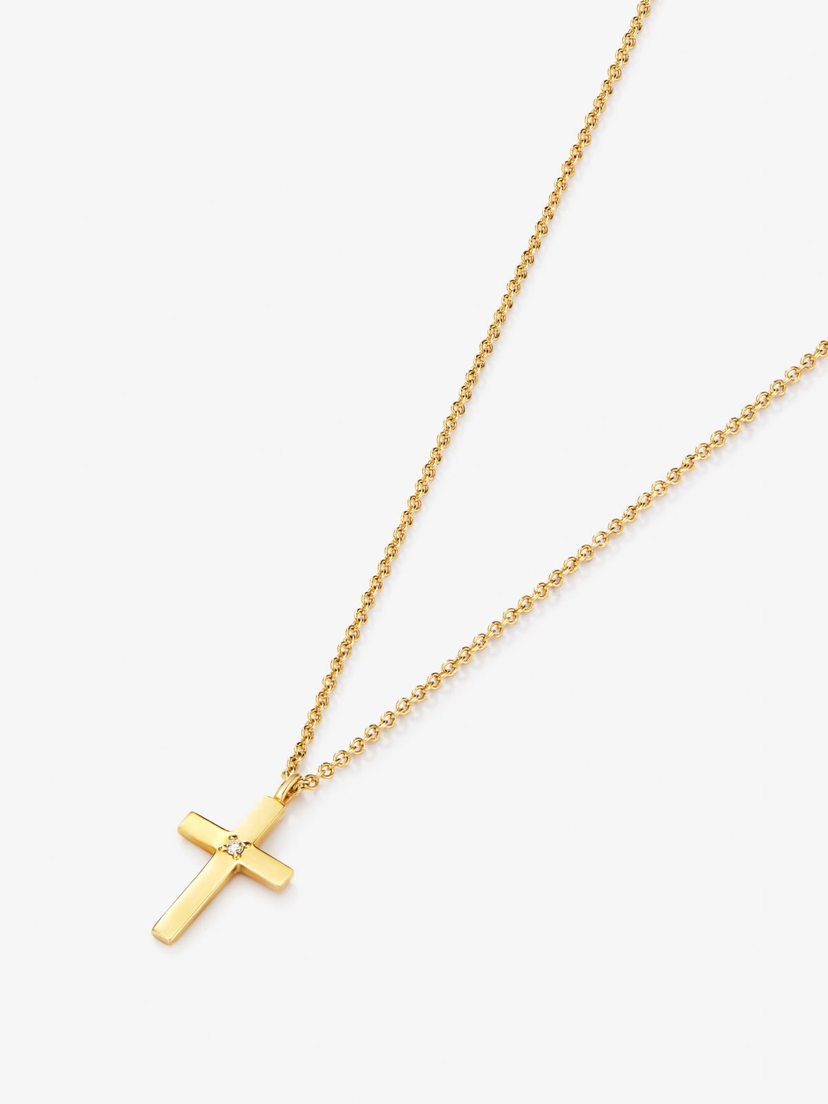 Colgante de oro amarillo de 18K con cruz mediana y diamante en talla brillante de 0,01 cts