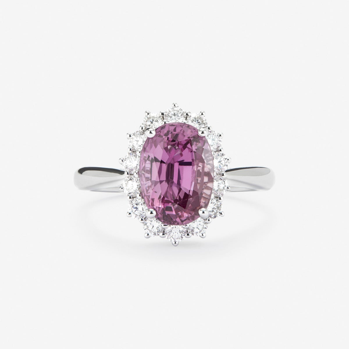 Anillo de oro blanco de 18K con zafiro rosa en talla oval de 0,55 cts y 12 diamantes en talla brillante con un total de 0,1 cts