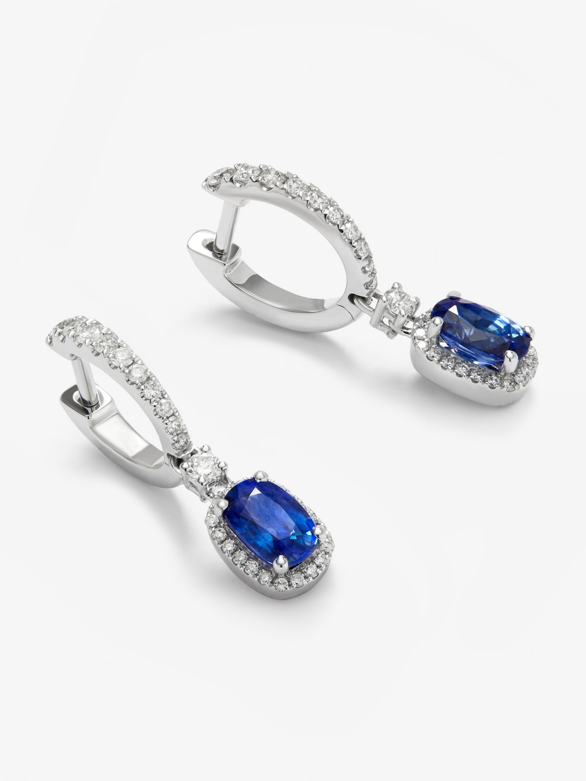 Pendientes de aro en oro blanco de 18K con zafiro azul royal en talla oval de 6,12 cts y 62 diamantes en talla brillante con un total de 0,73 cts