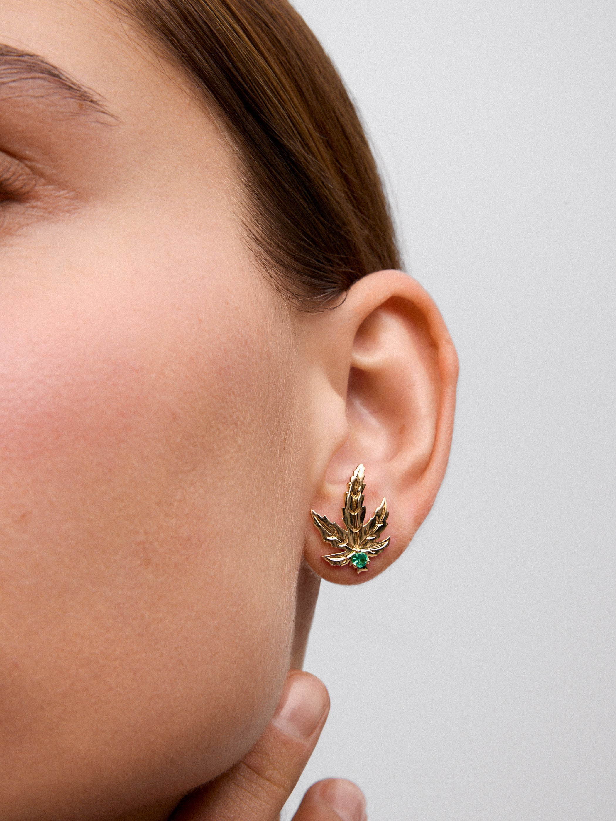 Pendientes de oro amarillo de 18K con 2 esmeraldas centrales con un total de 0,15 cts y forma de hoja de arce