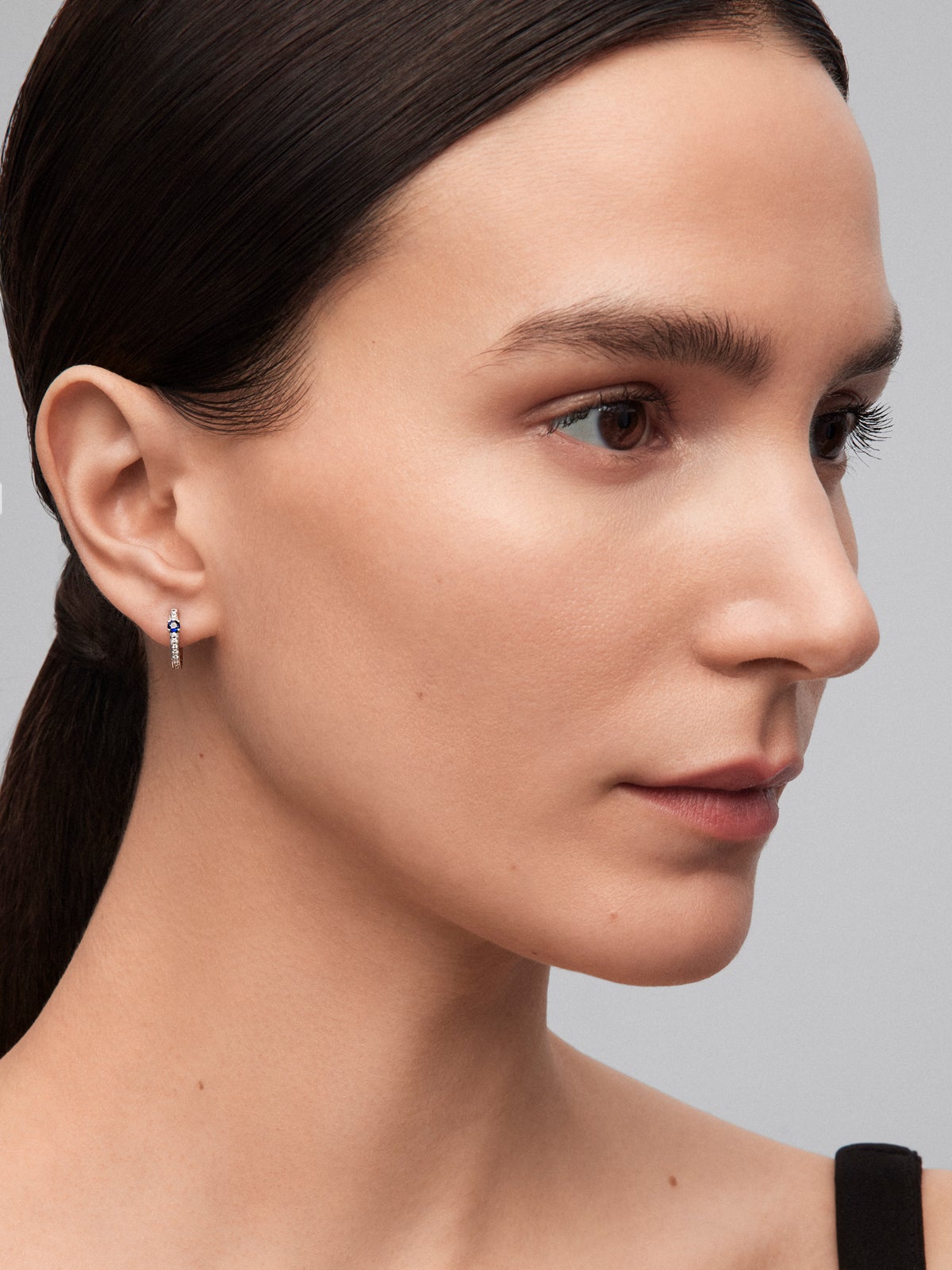 Pendientes de aro de oro blanco de 18K con 2 zafiros azules en talla brillante con un total de 0,15 cts y 26 diamantes en talla brillante con un total de 0,1 cts
