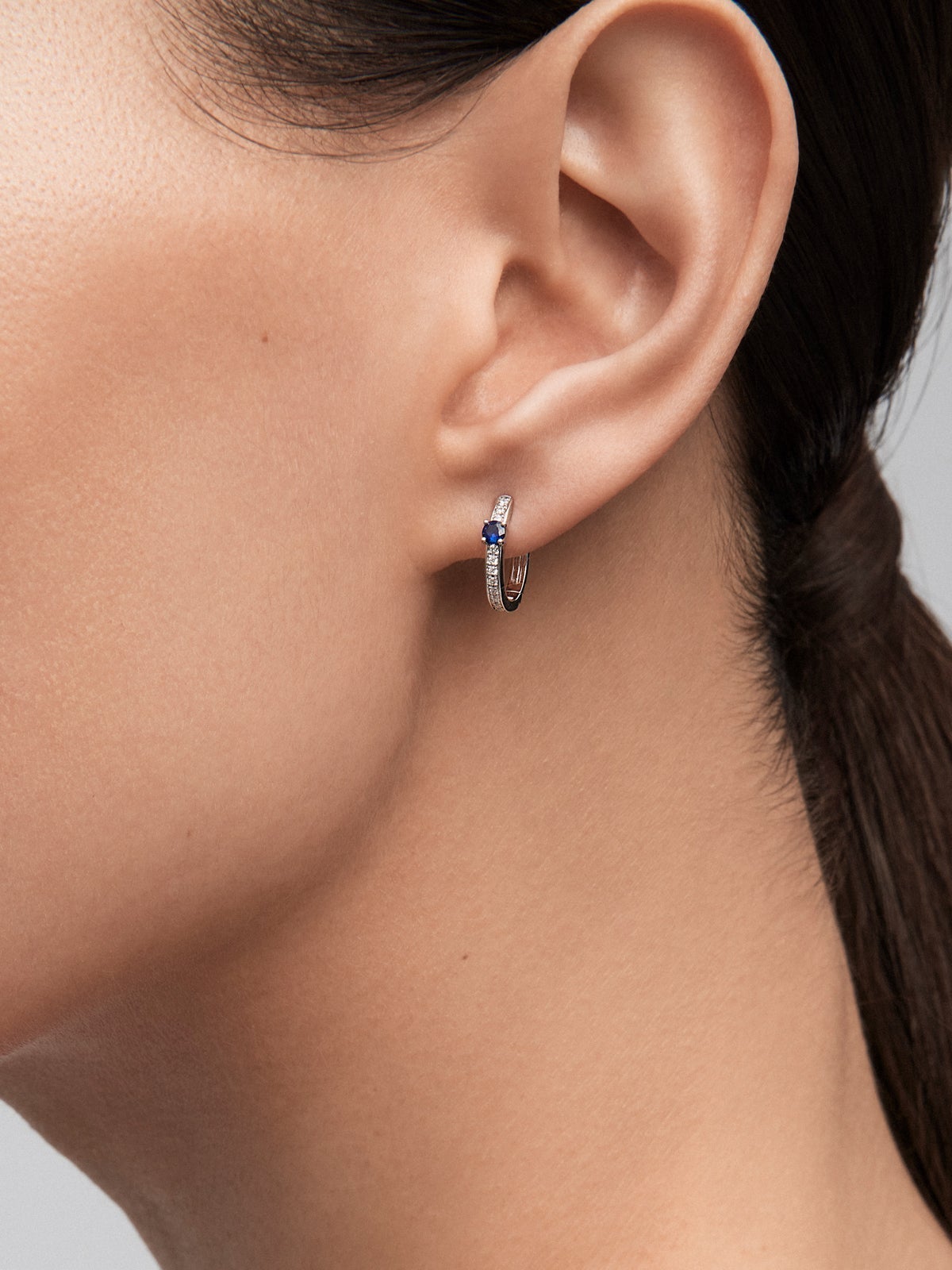 Pendientes de aro de oro blanco de 18K con 2 zafiros azules en talla brillante con un total de 0,15 cts y 26 diamantes en talla brillante con un total de 0,1 cts