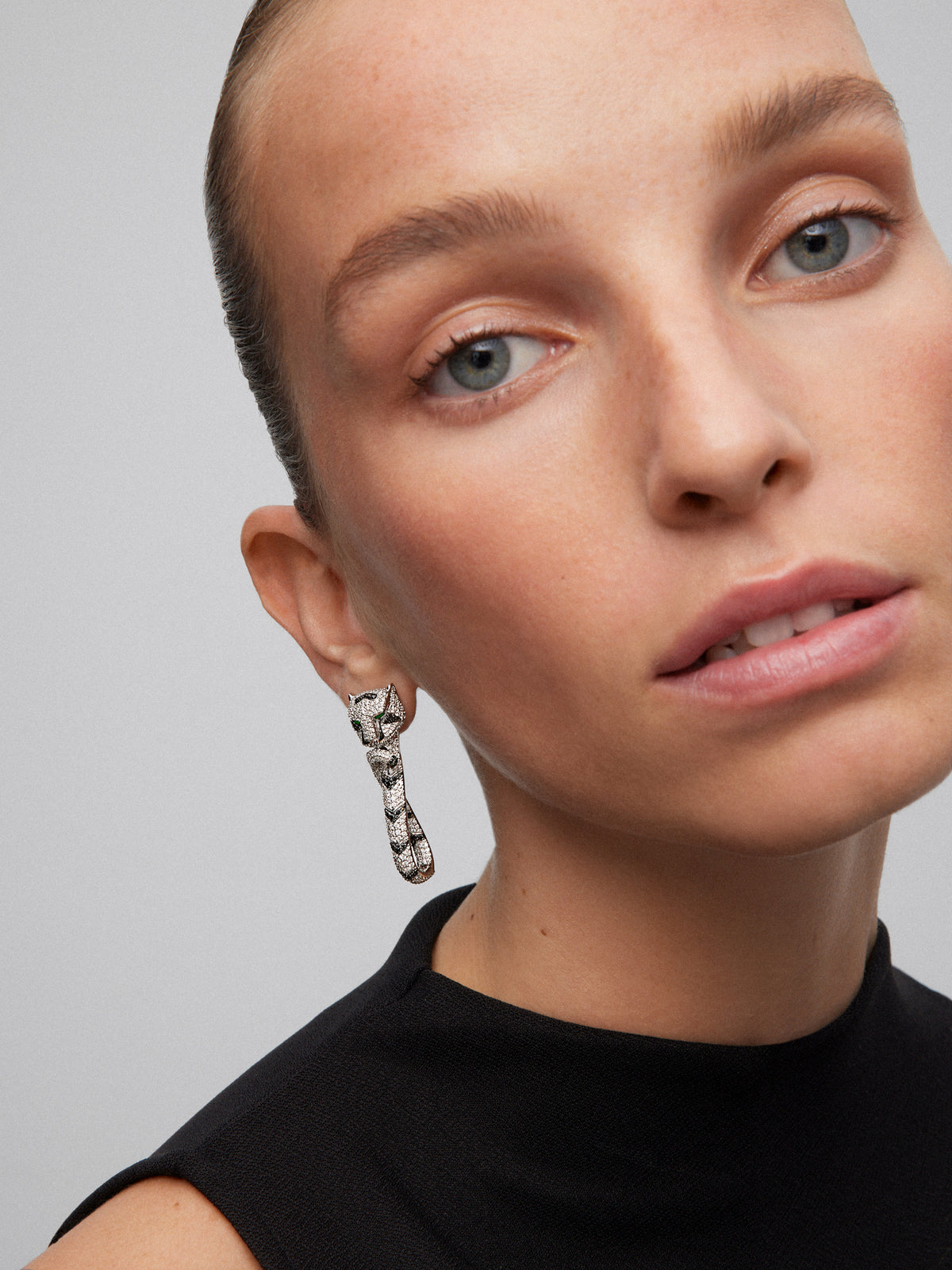 Pendientes con forma de tigre de oro blanco de 18K con diamantes blancos y negros en talla brillante con un total de 3,15 cts, y esmeraldas en talla trapecio con un total de 0,26 cts