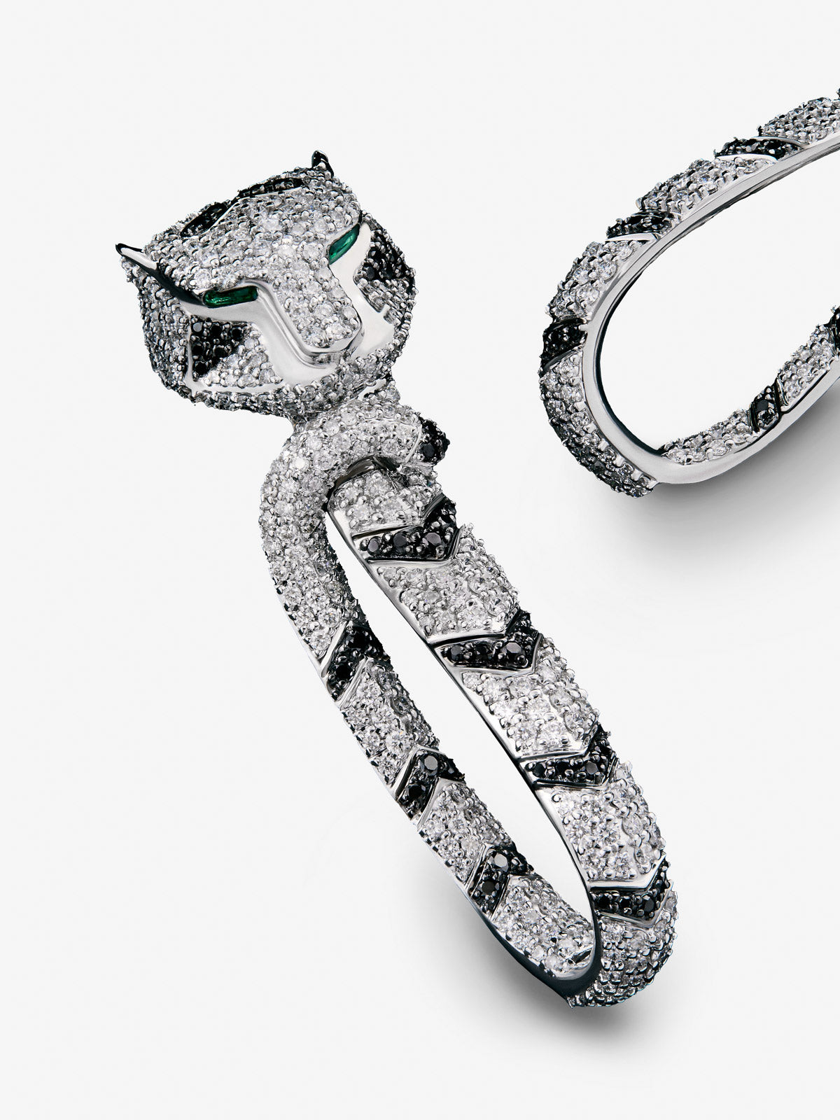 Pendientes con forma de tigre de oro blanco de 18K con diamantes blancos y negros en talla brillante con un total de 3,15 cts, y esmeraldas en talla trapecio con un total de 0,26 cts