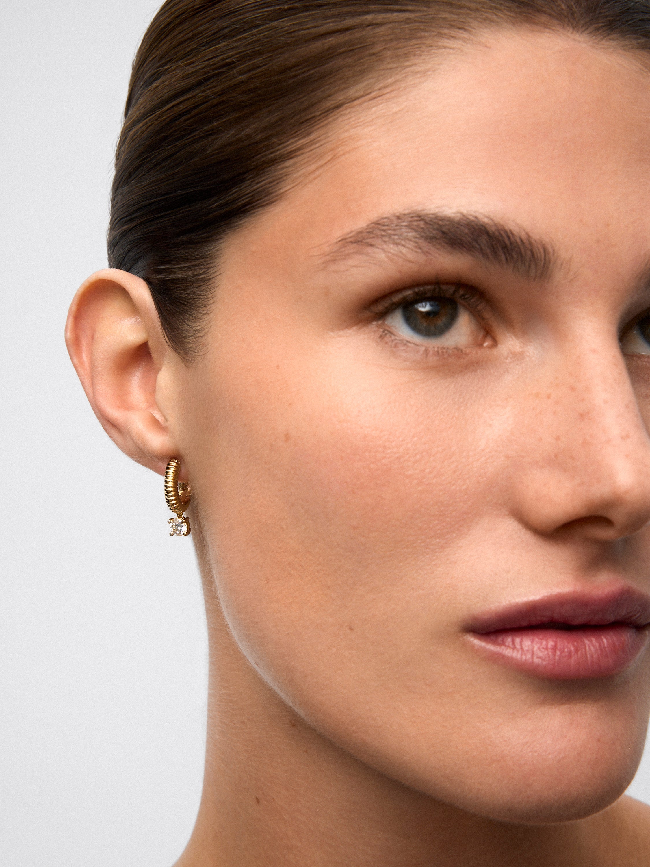 Pendientes gallonados de oro amarillo de 18K con dos diamantes en talla brillante con un total de 0,8 cts