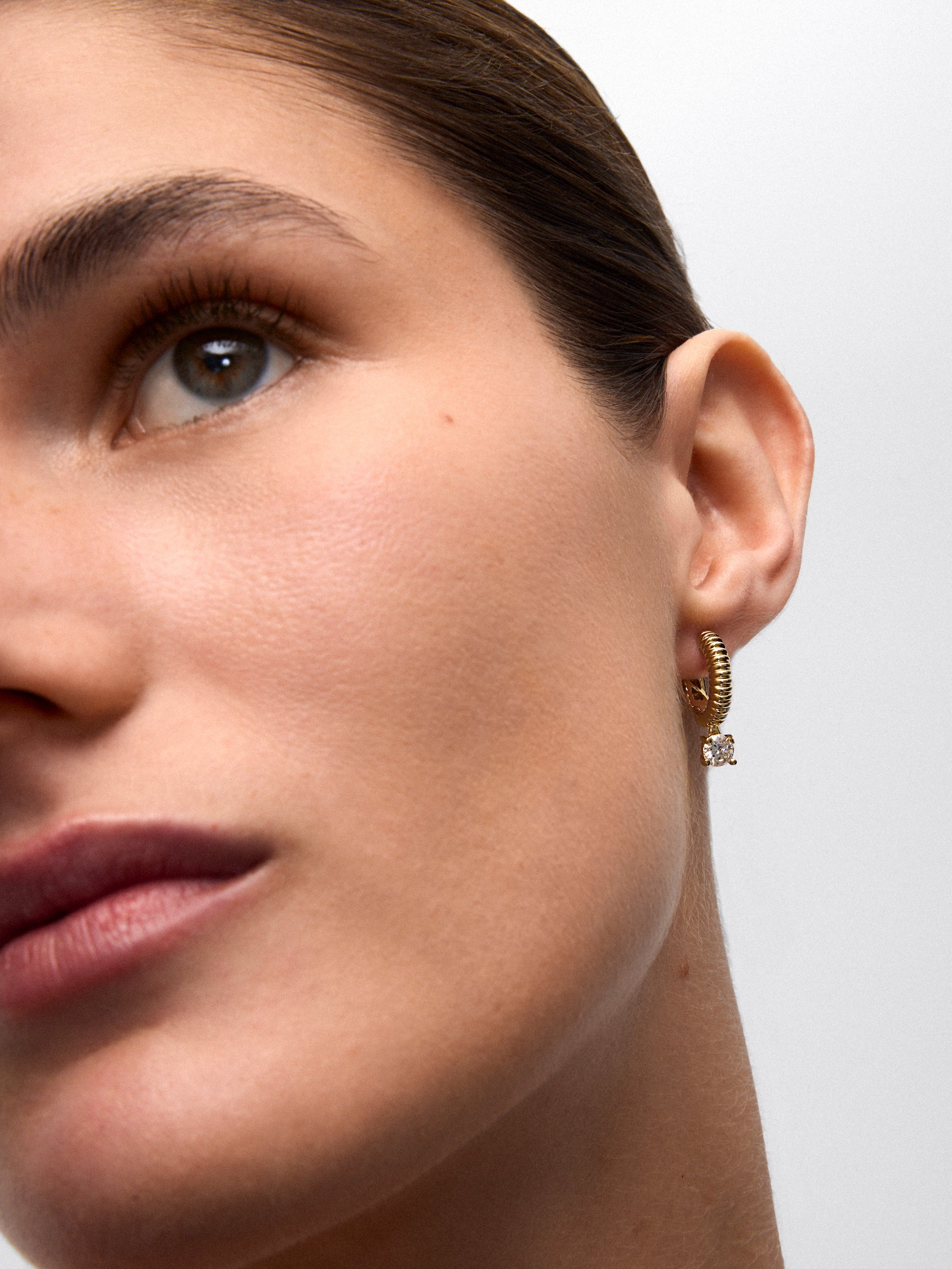 Pendientes gallonados de oro amarillo de 18K con dos diamantes en talla brillante con un total de 0,8 cts
