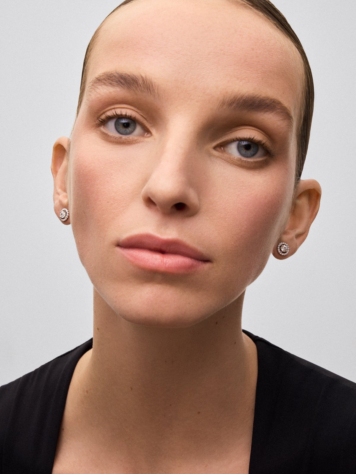 Pendientes de oro blanco de 18K con diamante solitario y orla de diamantes