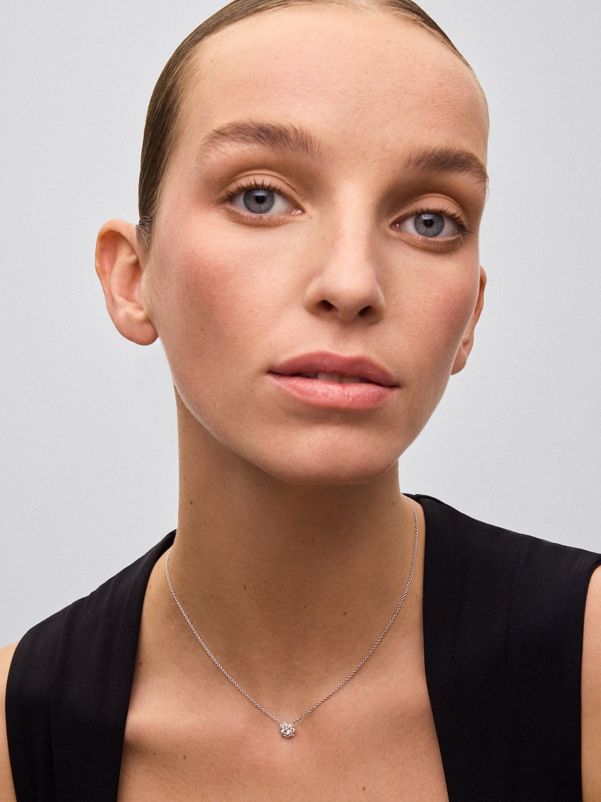 Colgante de oro blanco de 18K con diamante central en talla brillante de 0,2 cts y orla de 8 diamantes en talla brillante con un total de 0,26 cts en forma de estrella