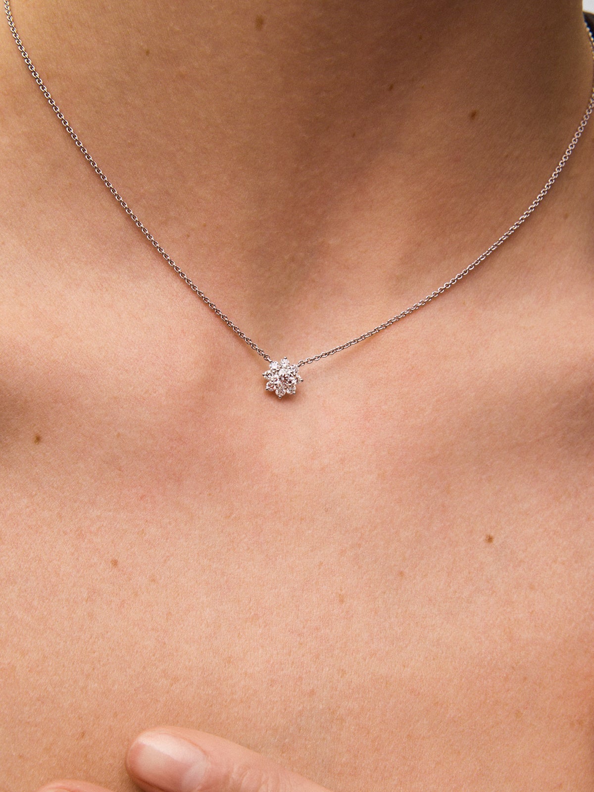 Colgante de oro blanco de 18K con diamante en talla brillante de 0,30 cts y forma de flor