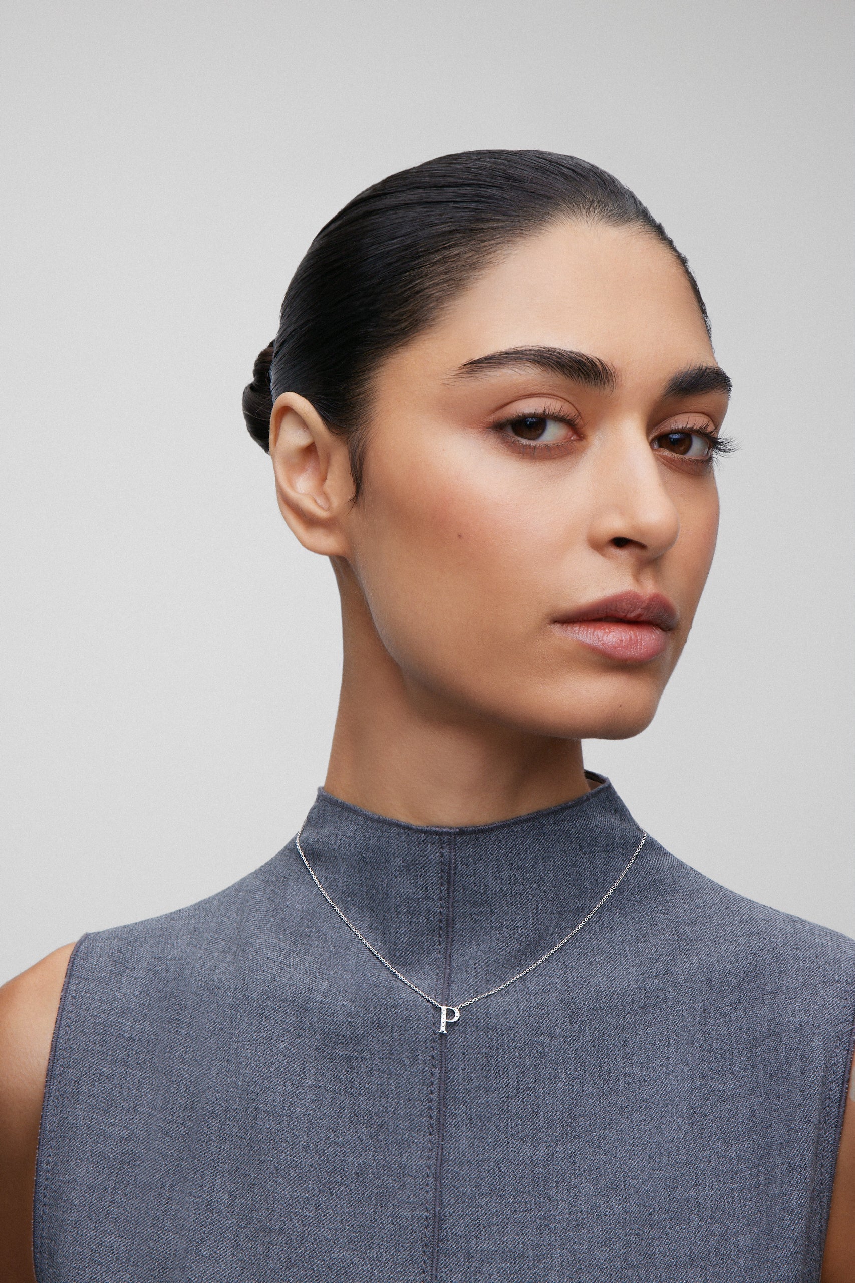 Colgante de oro blanco de 18K con letra P y 9 diamantes en talla brillante con un total de 0,06 cts