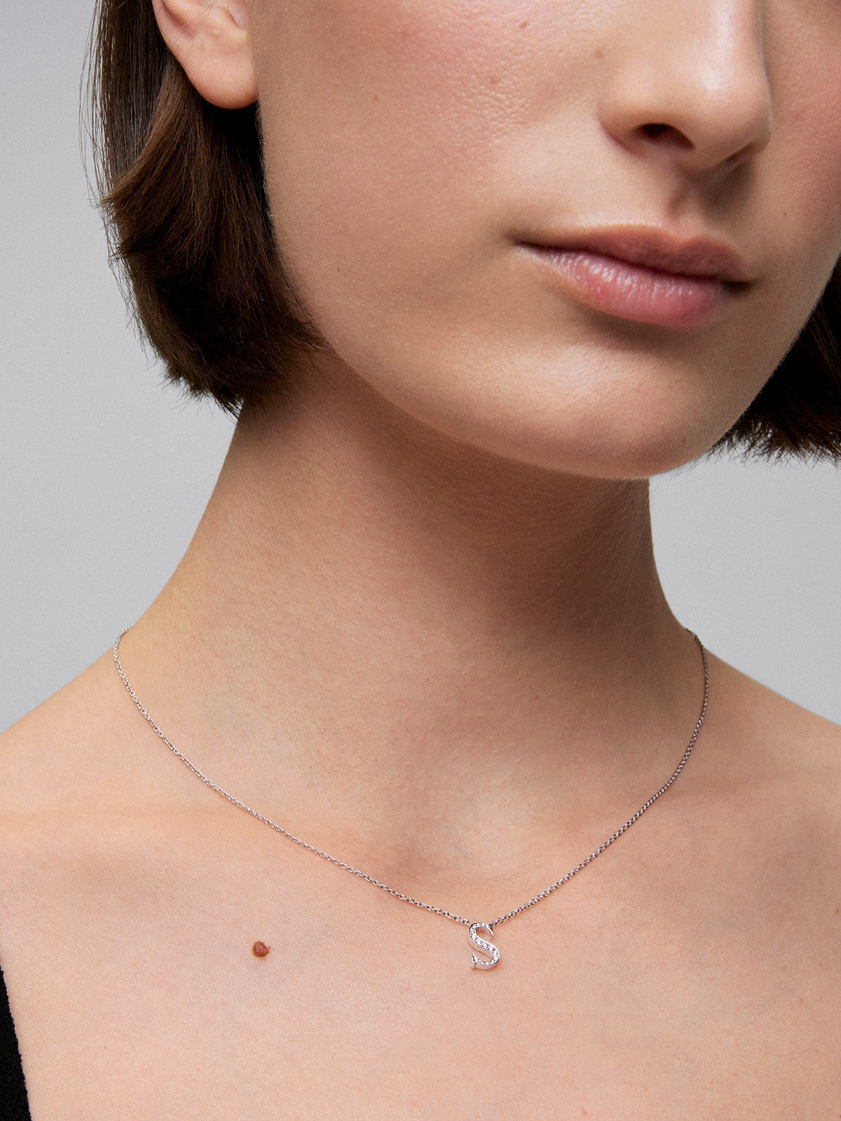 Colgante de oro blanco de 18K con letra S y 16 diamantes en talla brillante con un total de 0,07 cts