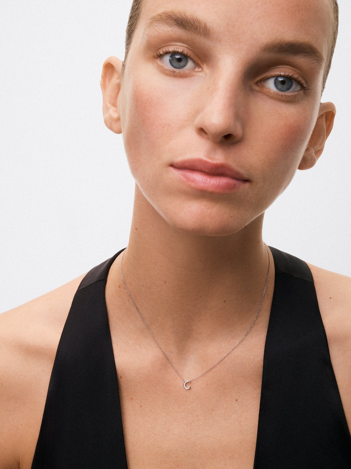 Colgante de oro blanco de 18K con letra C y 9 diamantes en talla brillante con un total de 0,023 cts