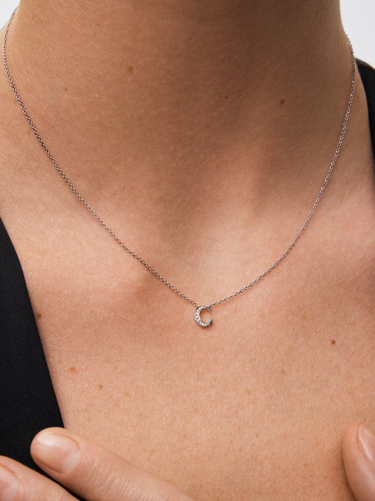 Colgante de oro blanco de 18K con letra C y 9 diamantes en talla brillante con un total de 0,023 cts