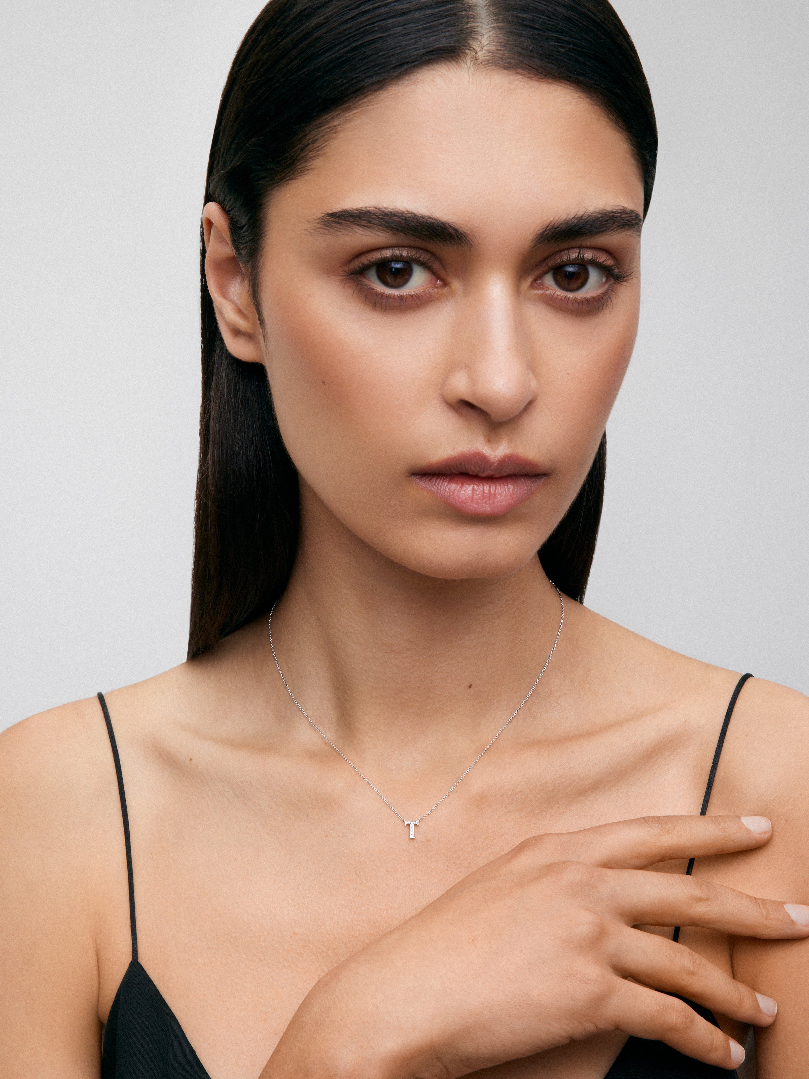 Colgante de oro blanco de 18K con letra T en pavé de 10 diamantes en talla brillante con un total de 0,0205 cts