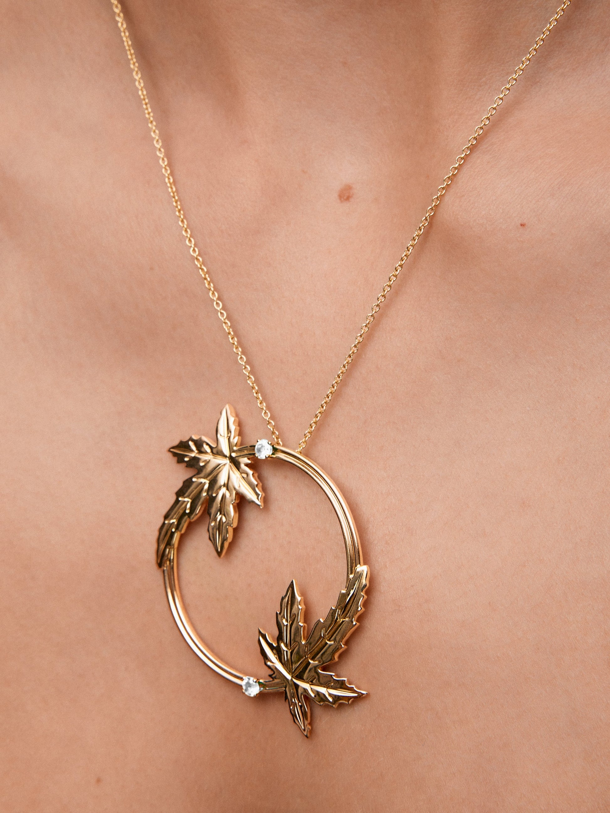 Colgante de oro amarillo de 18K con dos diamantes en talla brillante con un total de 0,33 cts y forma de hojas de arce