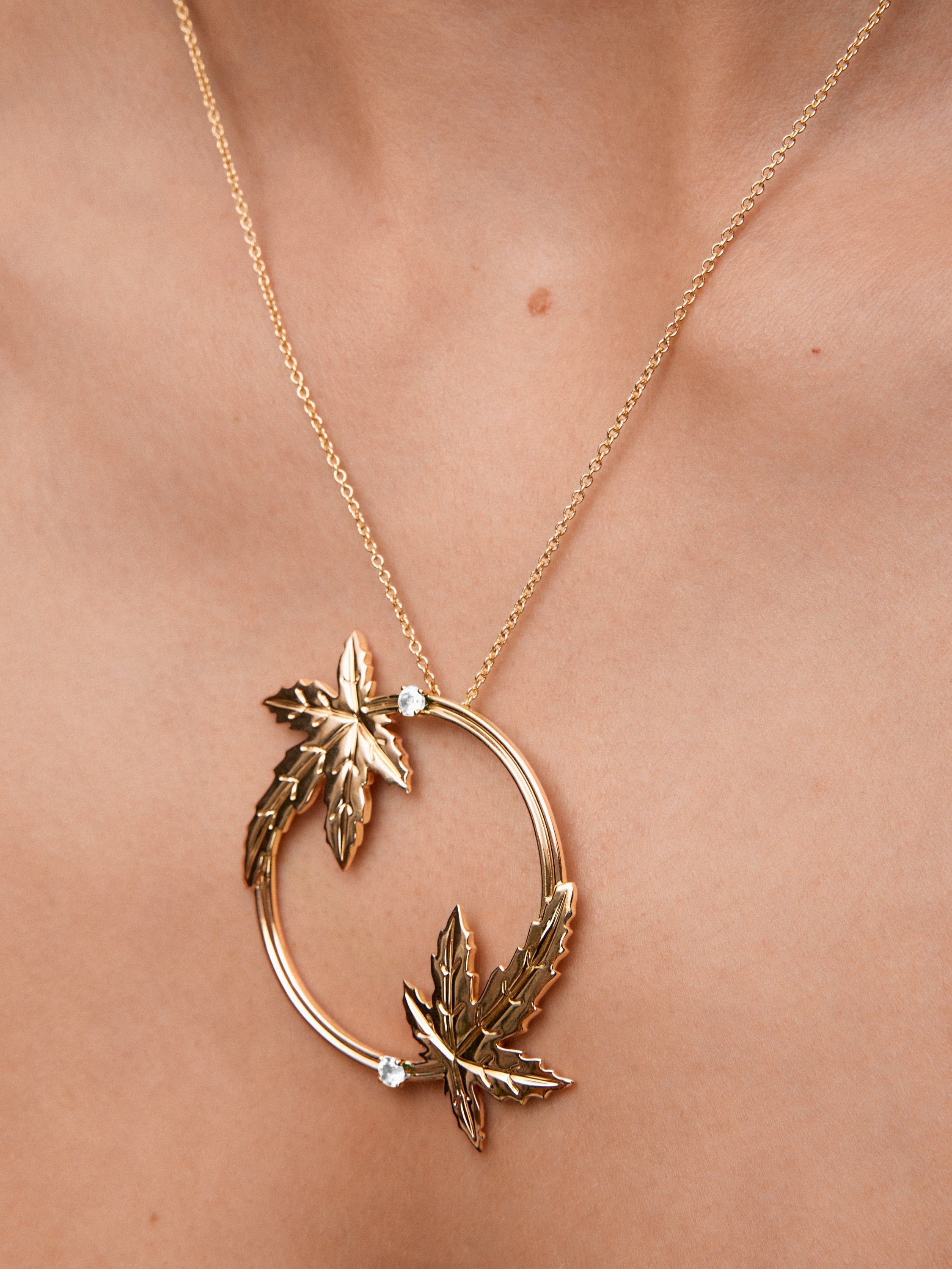 Colgante de oro amarillo de 18K con dos diamantes en talla brillante con un total de 0,33 cts y forma de hojas de arce