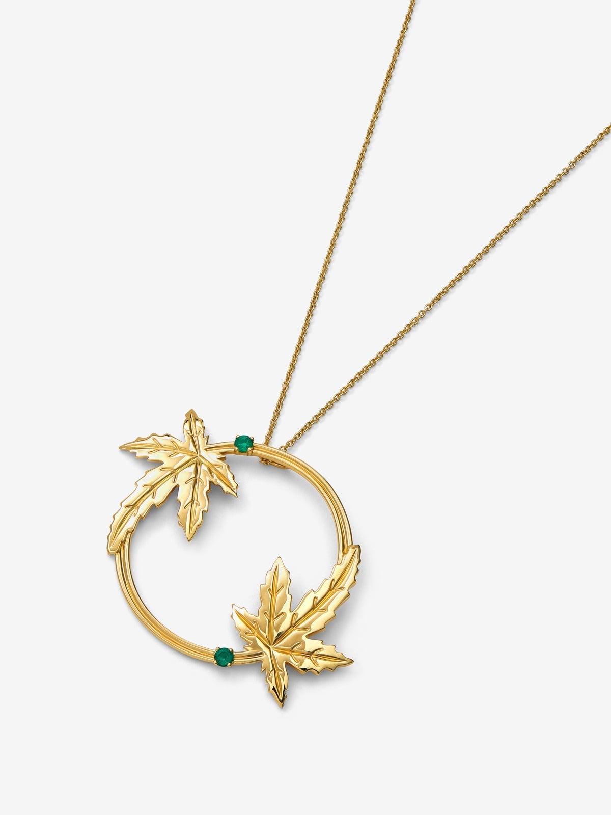 Colgante de oro amarillo de 18K con dos esmeraldas en talla brillante con un total de 0,29 cts y forma de hojas de arce