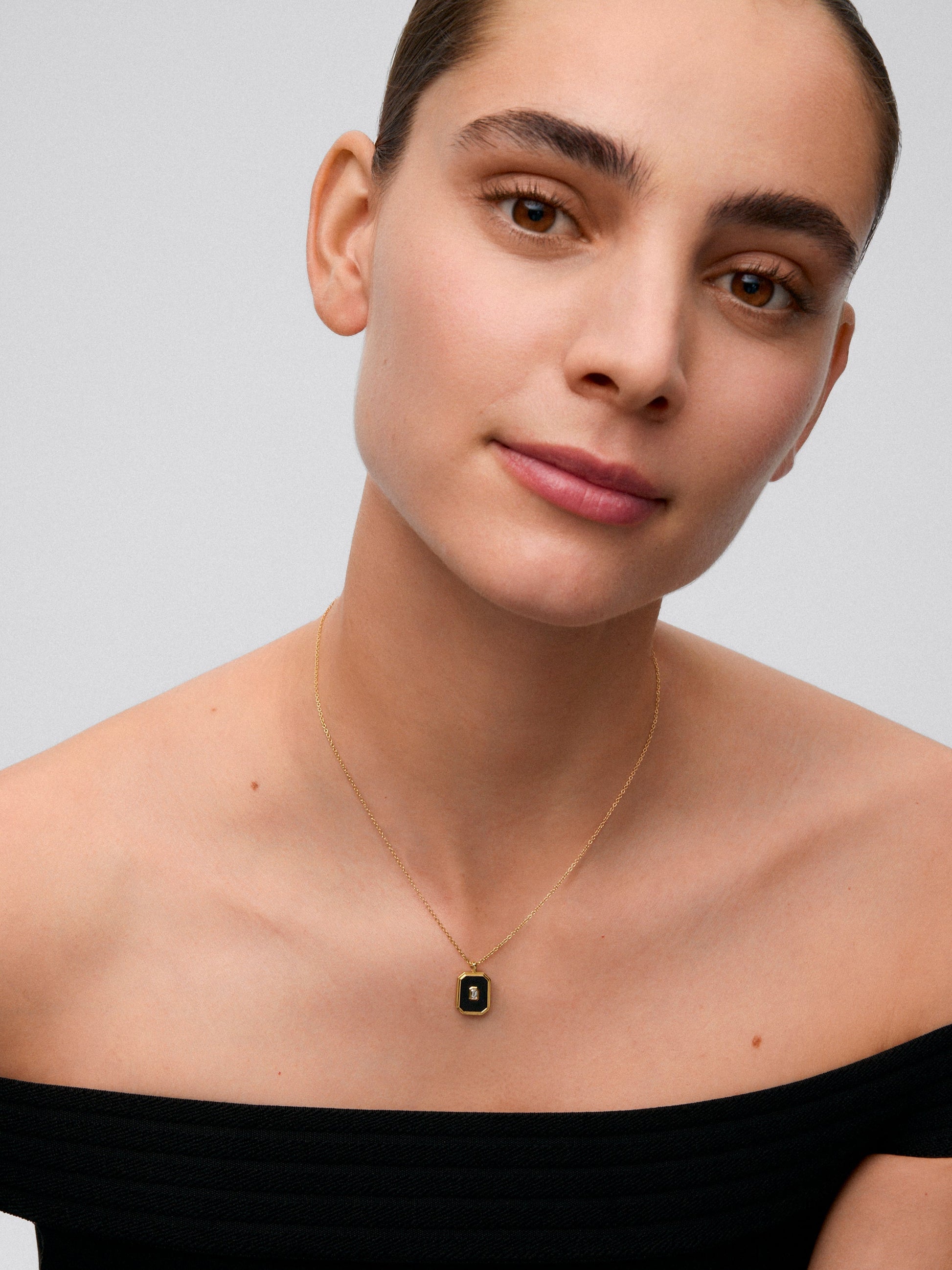 Colgante de oro amarillo de 18K con ónix negro de 1,45 cts y diamante blanco en talla esmeralda de 0,1 cts