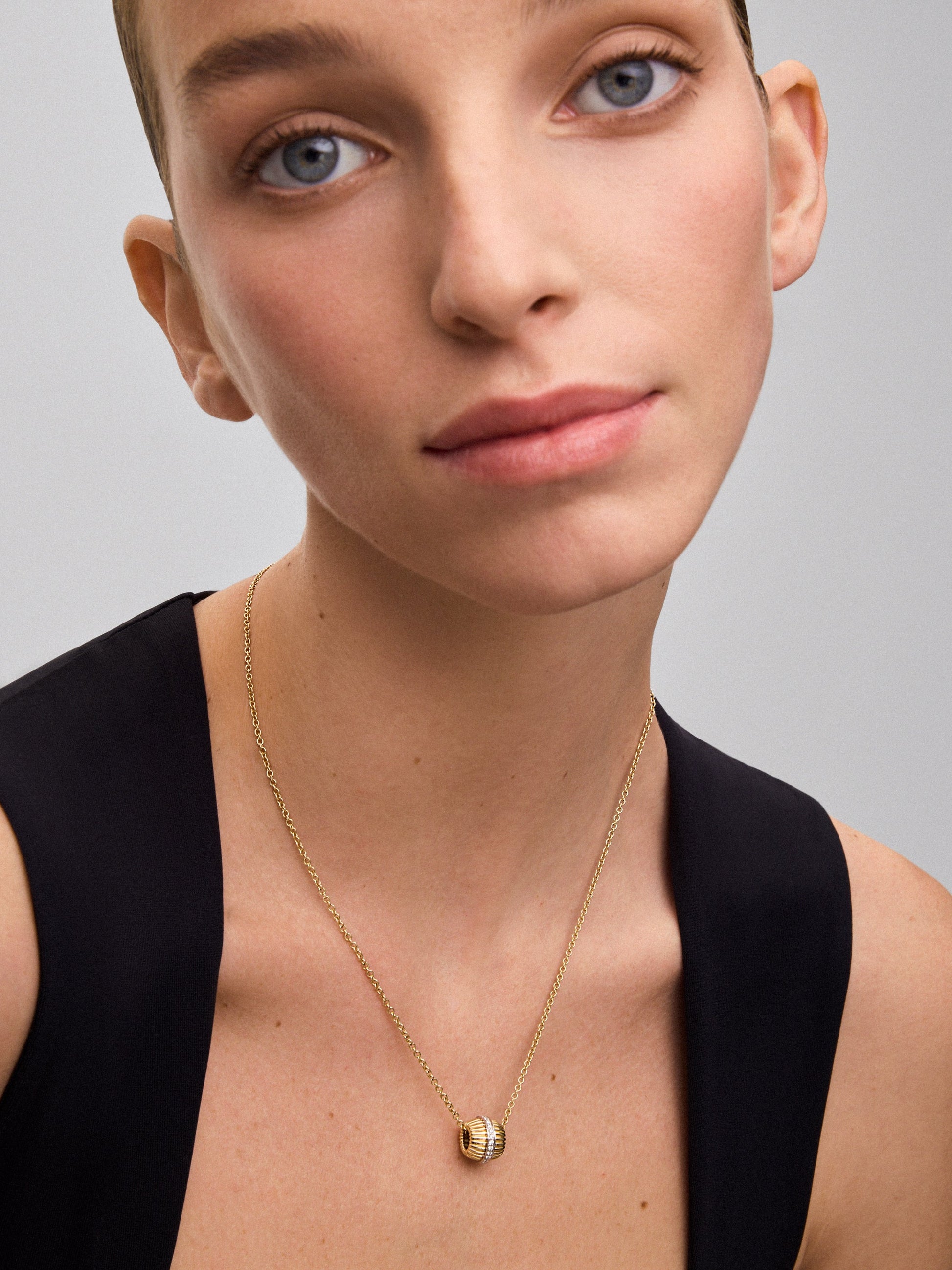 Colgante gallonado de oro blanco y amarillo de 18K con pavé de diamantes en talla brillante con un total de 0,19 cts