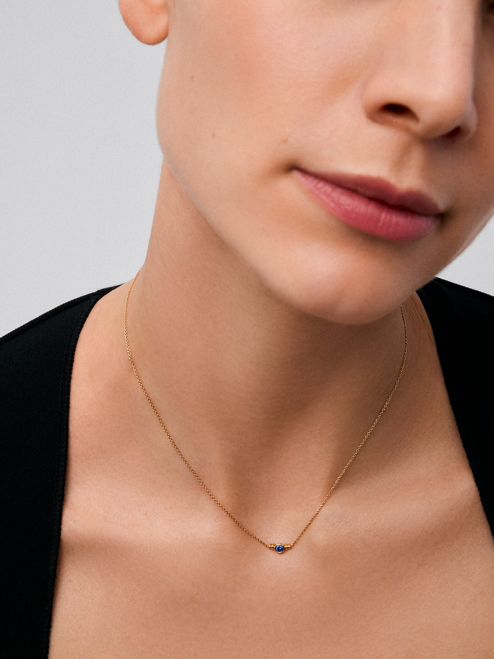 Colgante de oro amarillo de 18K con zafiro en talla brillante de 0,1cts 