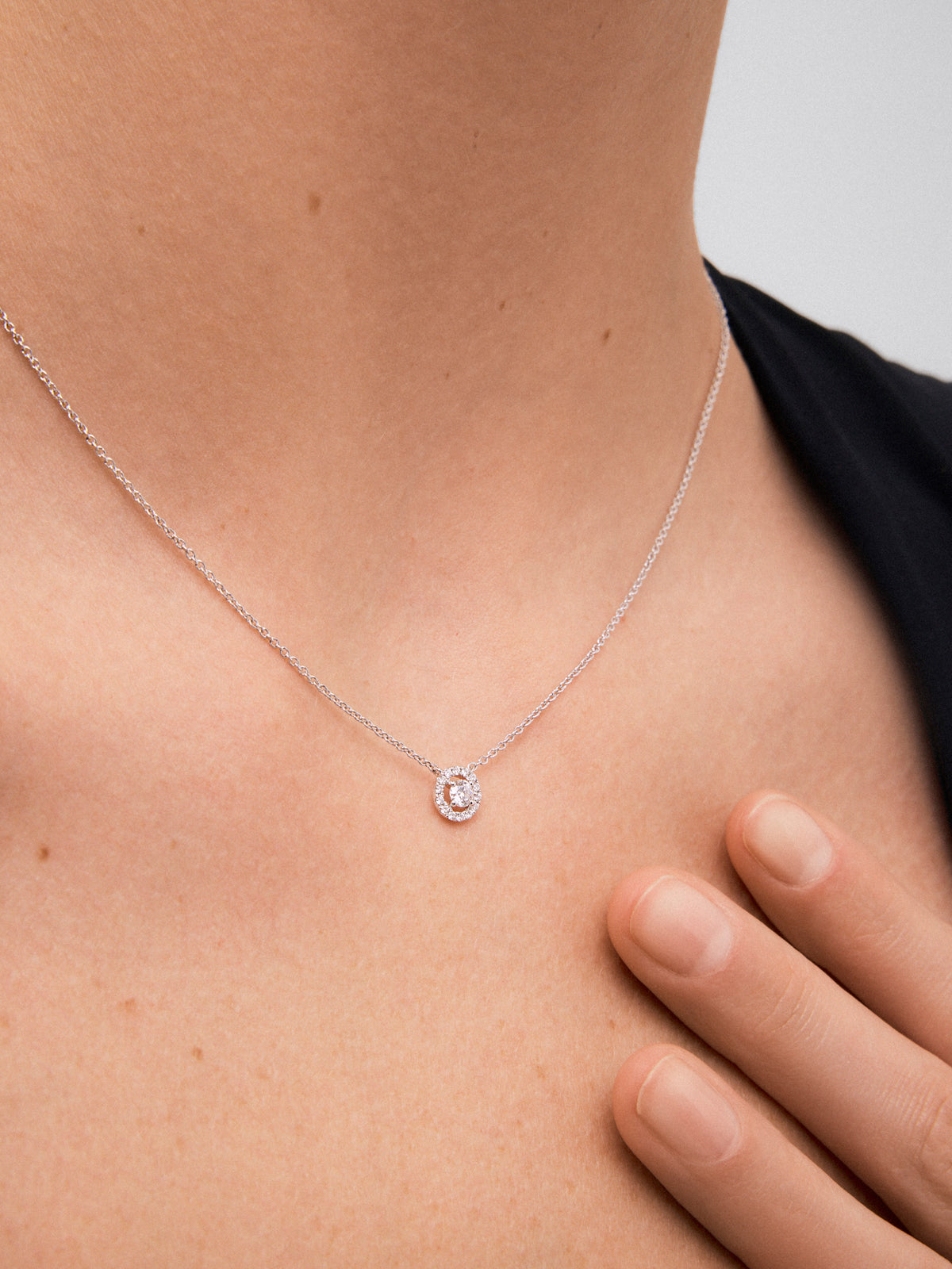 Colgante cadena de oro blanco de 18K con diamante solitario y orla de diamantes