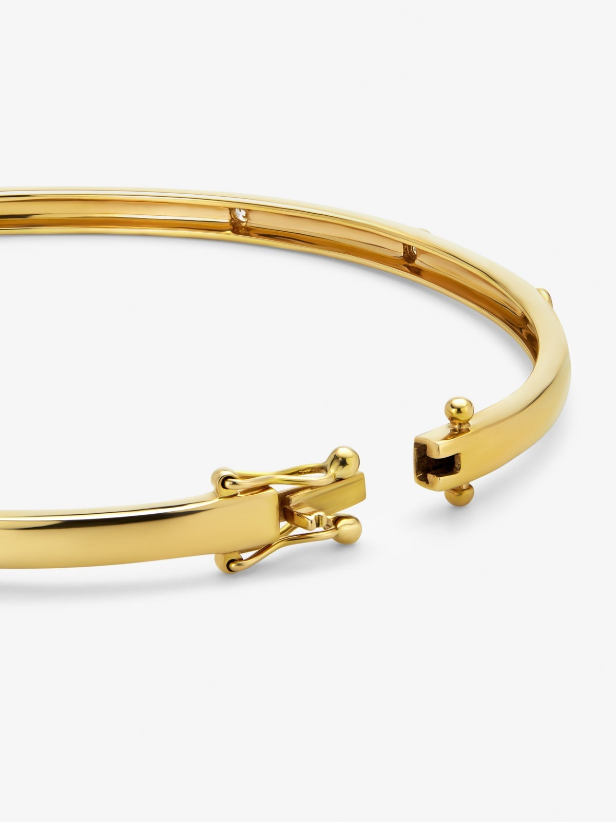 Pulsera rígida de oro amarillo de 18K con 3 diamantes en talla brillante con un total de 0,07 cts