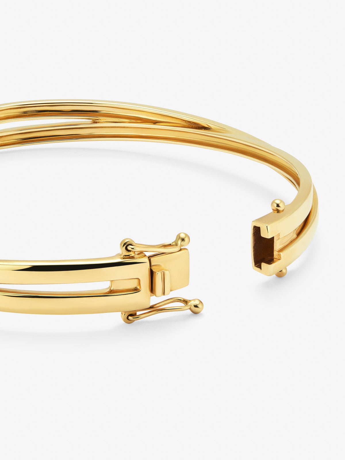 Pulsera rígida cruzada de oro amarillo de 18K con 3 diamantes en talla brillante con un total de 0,04 cts