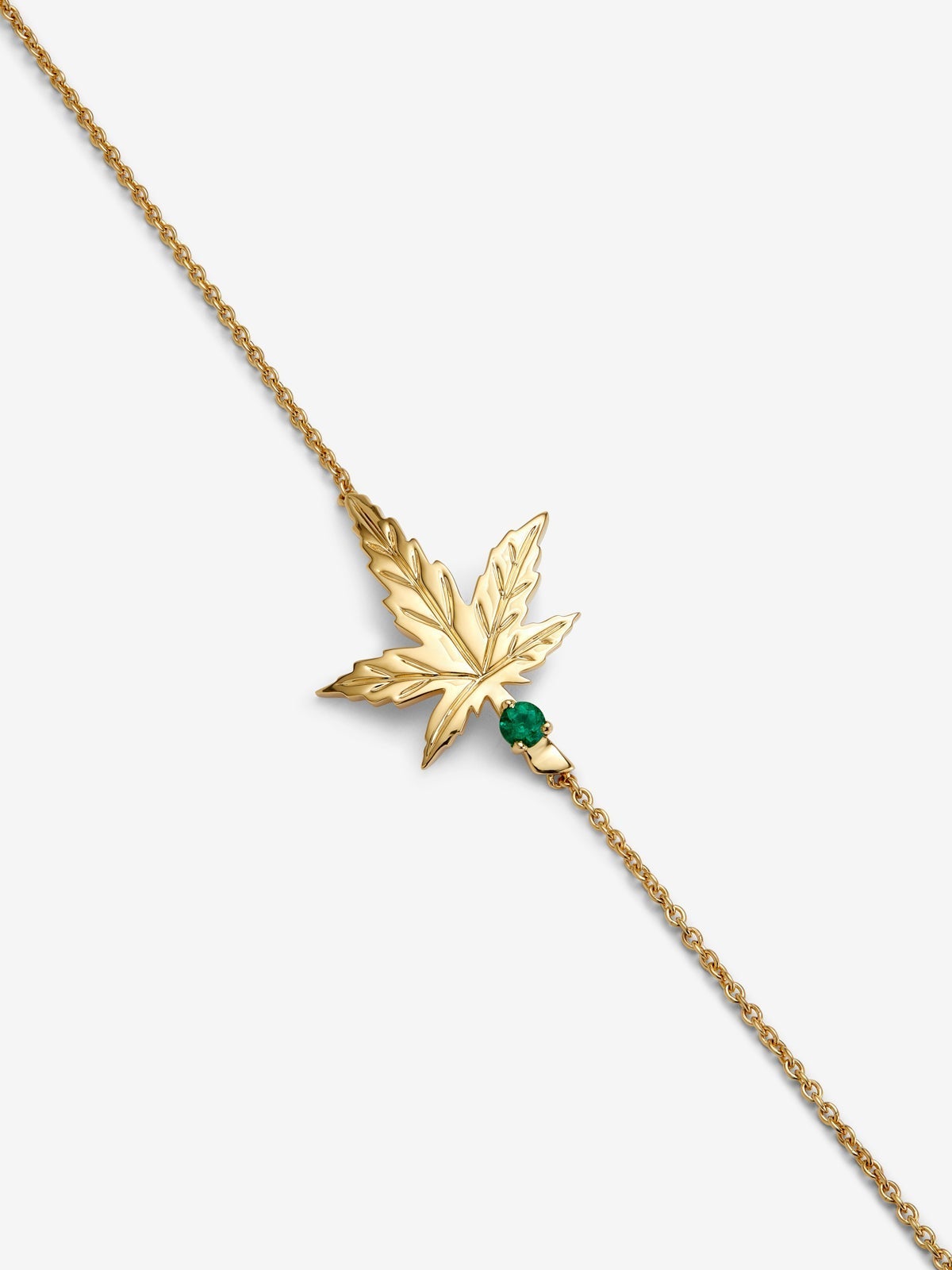 Pulsera de oro amarillo de 18K con una esmeralda en talla brillante de 0,11 cts y forma de hoja de arce