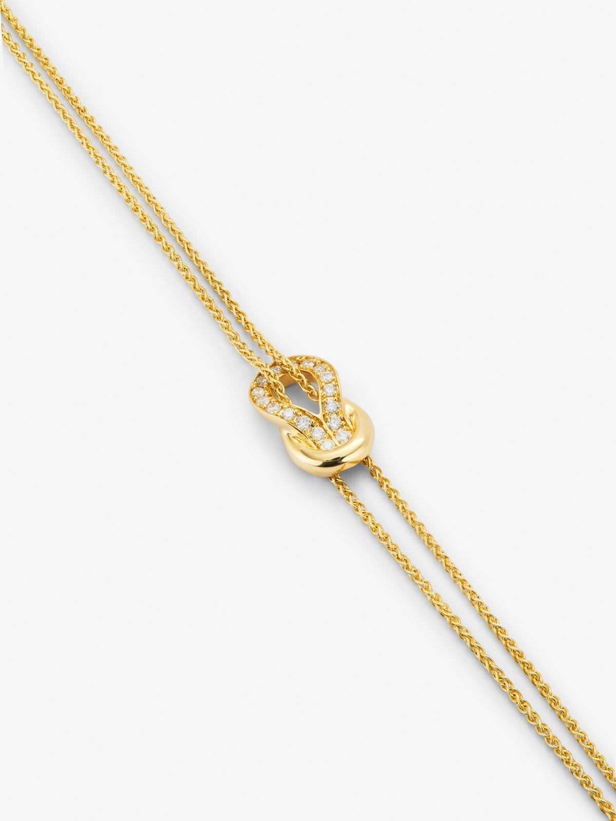 Pulsera de oro amarillo de 18K con 17 diamantes en talla brillante con un total de 0,15 cts y forma de nudo