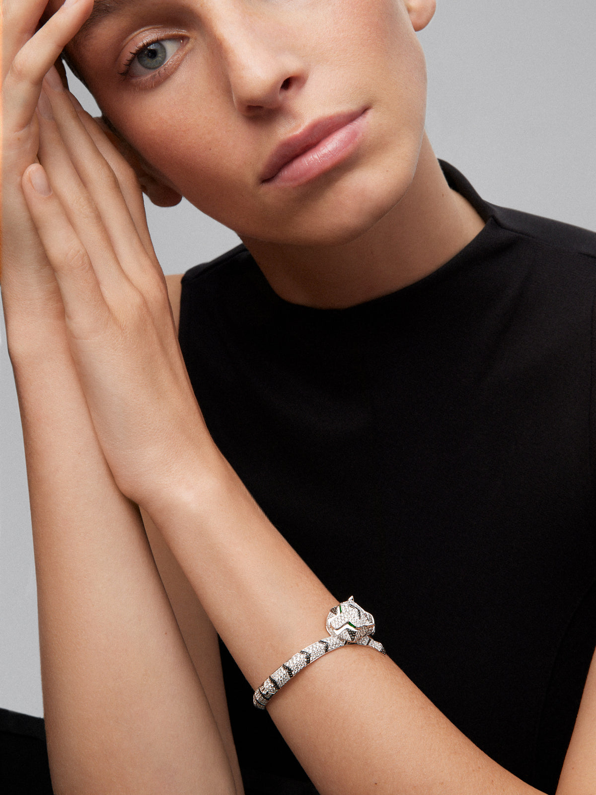 Pulsera rígida con forma de tigre en oro blanco de 18K con diamantes blancos y negros en talla brillante con un total de 9,66 cts y esmeraldas en talla trapecio con un total de 0,13 cts