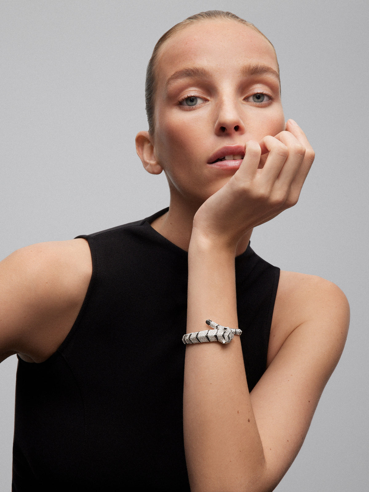 Pulsera rígida con forma de tigre en oro blanco de 18K con diamantes blancos y negros en talla brillante con un total de 9,66 cts y esmeraldas en talla trapecio con un total de 0,13 cts