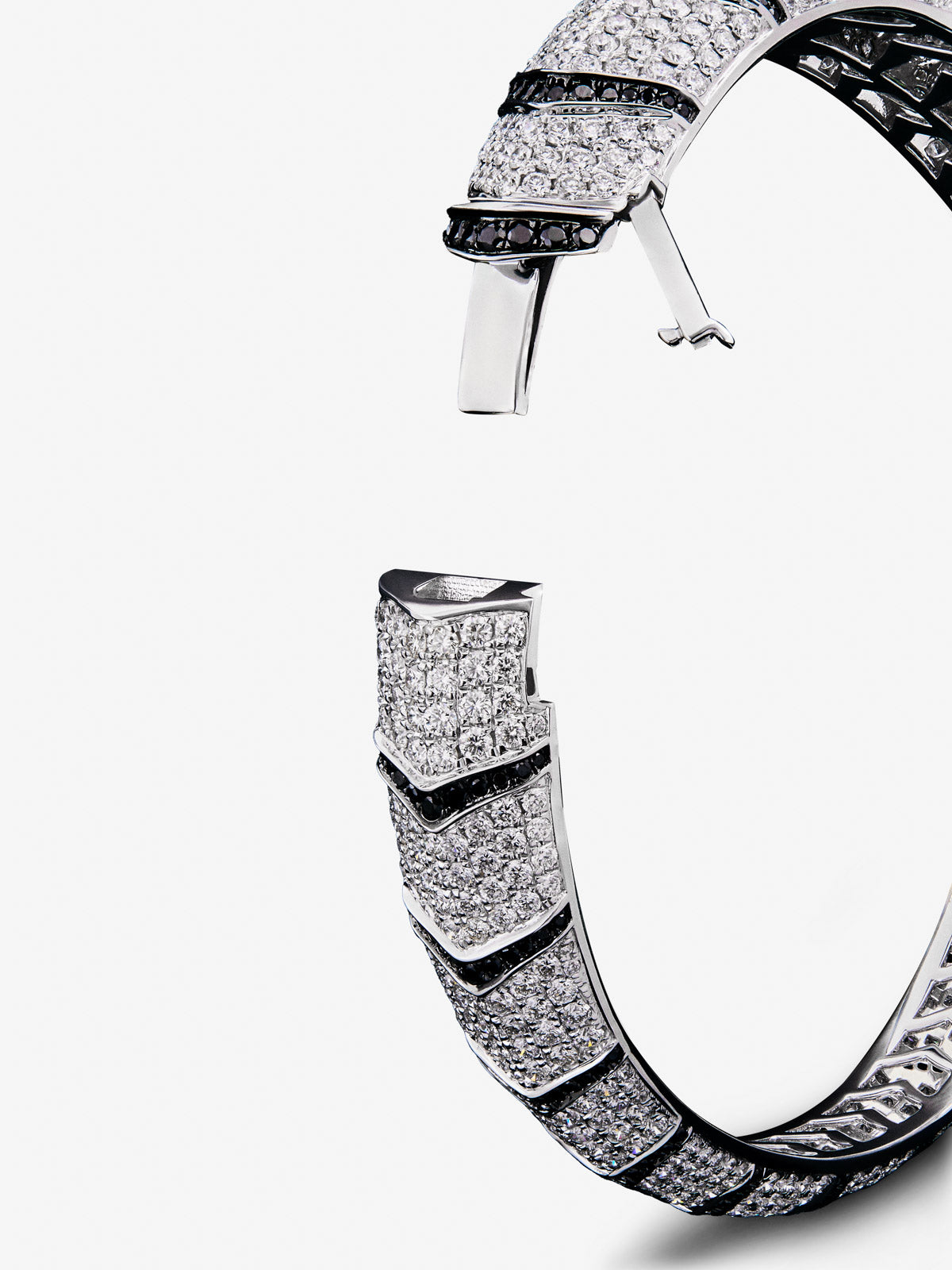 Pulsera rígida con forma de tigre en oro blanco de 18K con diamantes blancos y negros en talla brillante con un total de 9,66 cts y esmeraldas en talla trapecio con un total de 0,13 cts