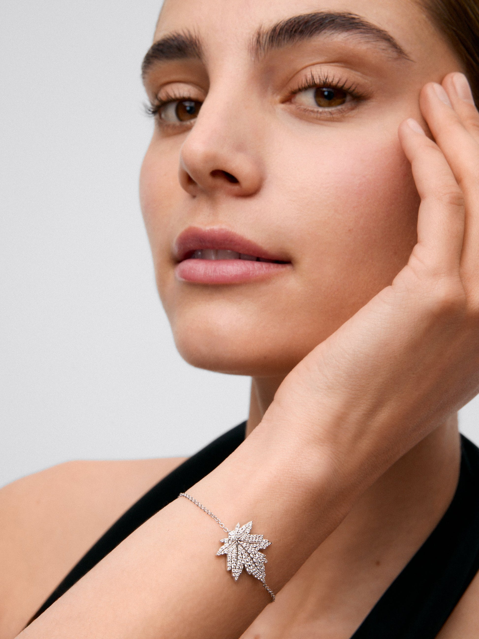 Pulsera de oro blanco de 18K con diamante central en talla brillante de 0,14 cts, pavé de diamantes y forma de hoja de arce