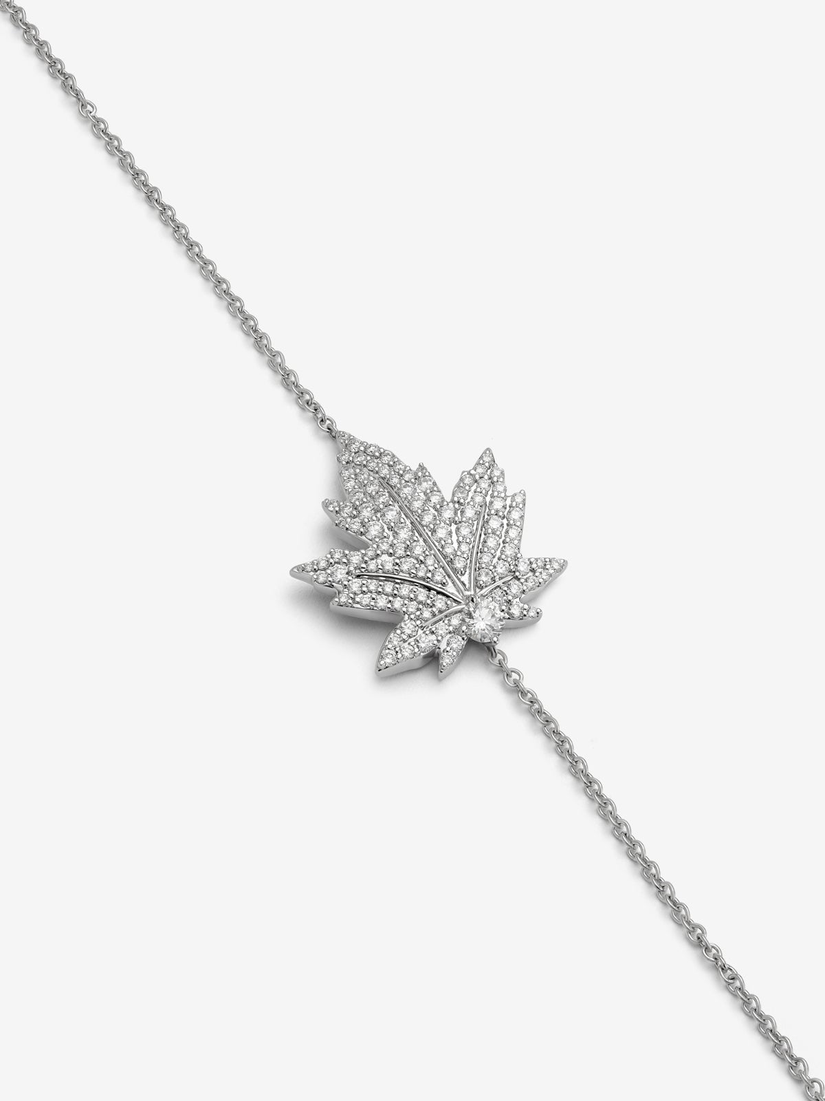 Pulsera de oro blanco de 18K con diamante central en talla brillante de 0,14 cts, pavé de diamantes y forma de hoja de arce