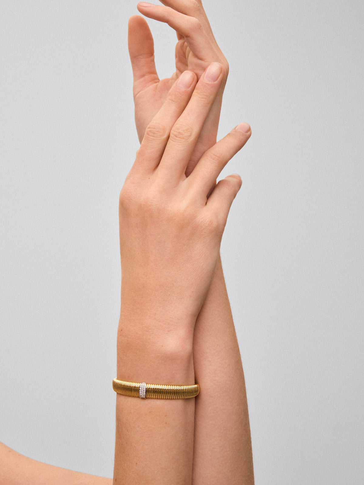 Pulsera rígida gallonada de oro blanco y amarillo de 18K con pavé de diamantes en talla brillante con un total de 0,16 cts