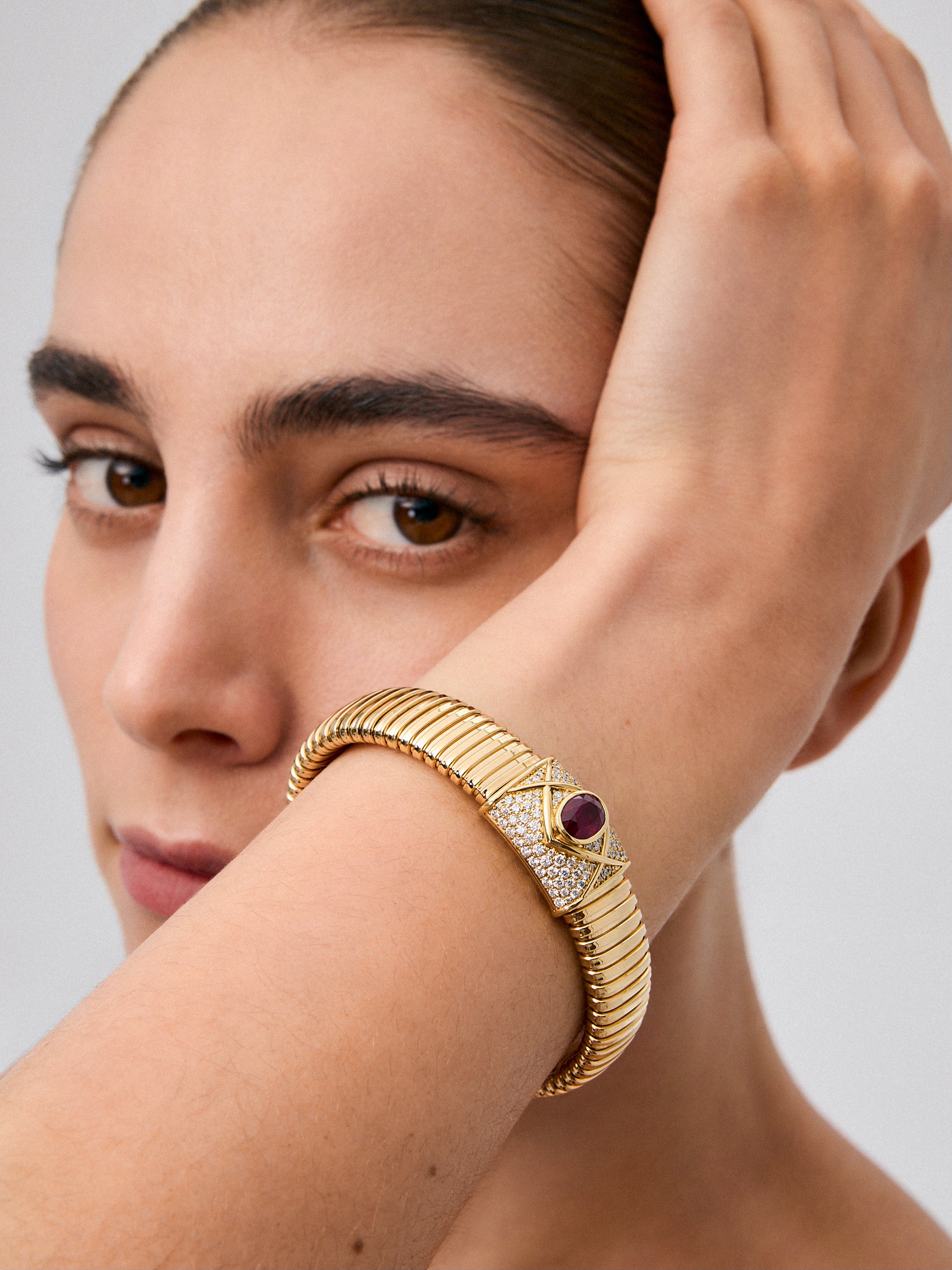 Pulsera tubogas de oro amarillo de 18K con rubí sangre de pichón en talla oval de 2,2 cts y 98 diamantes en talla brillante con un total de 0,09 cts