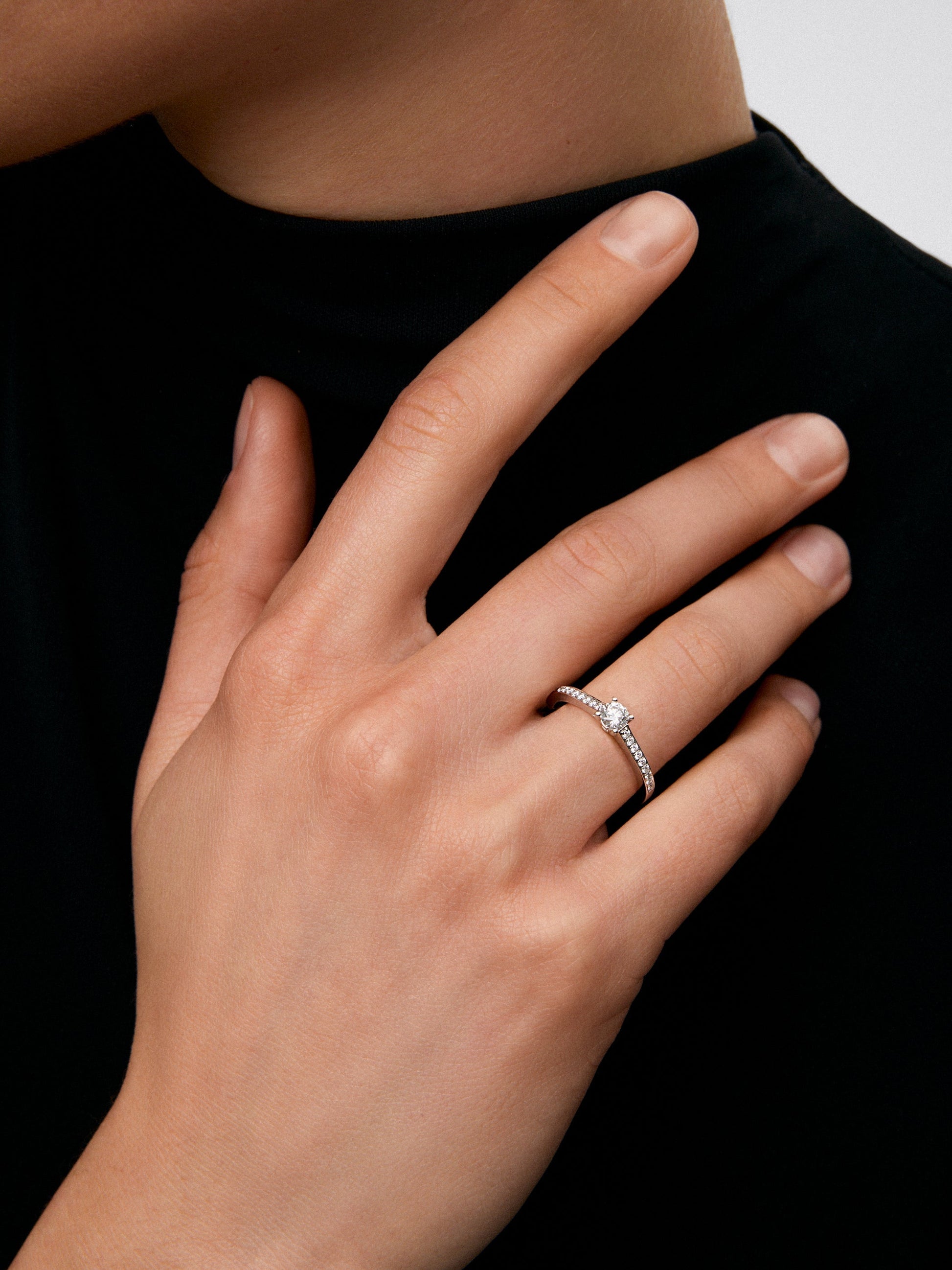 Anillo solitario de oro blanco de 18K con diamante central en talla brillante de 0,3 cts y brazo de 18 diamantes en talla brillante con un total de 0,13 cts