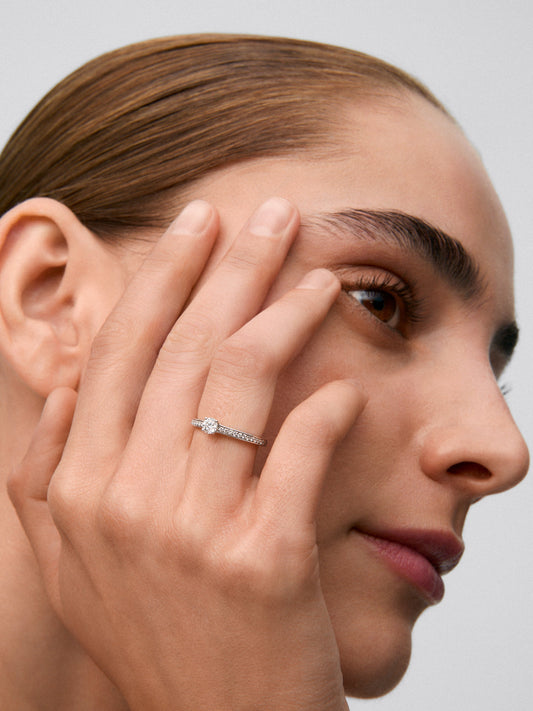 Anillo solitario de oro blanco de 18K con diamante central de 0,25 cts y brazo de diamantes en talla brillante