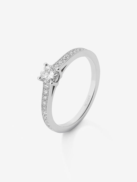 Anillo solitario de oro blanco de 18K con diamante central de 0,30 cts y brazo de diamantes en talla brillante