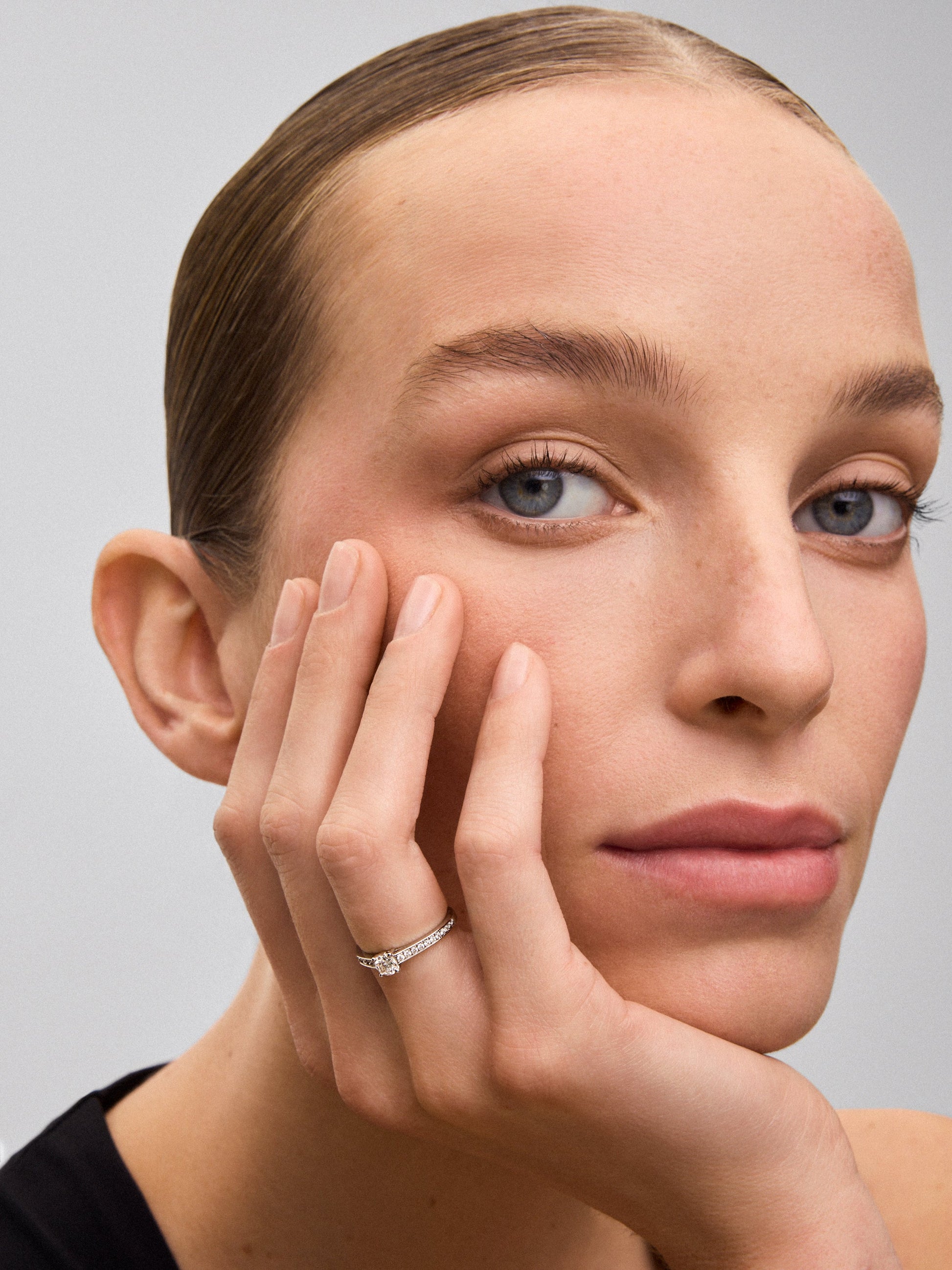 Anillo solitario de oro blanco de 18K con diamante central de 0,30 cts y brazo de diamantes en talla brillante