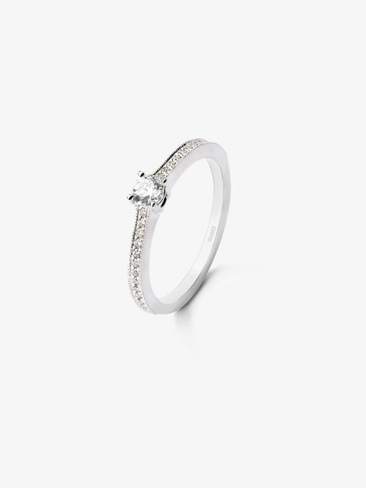 Anillo solitario de oro blanco de 18K con un diamante central en talla brillante de 0,23 cts y brazo de 29 diamantes en talla brillante con un total de 0,12 cts
