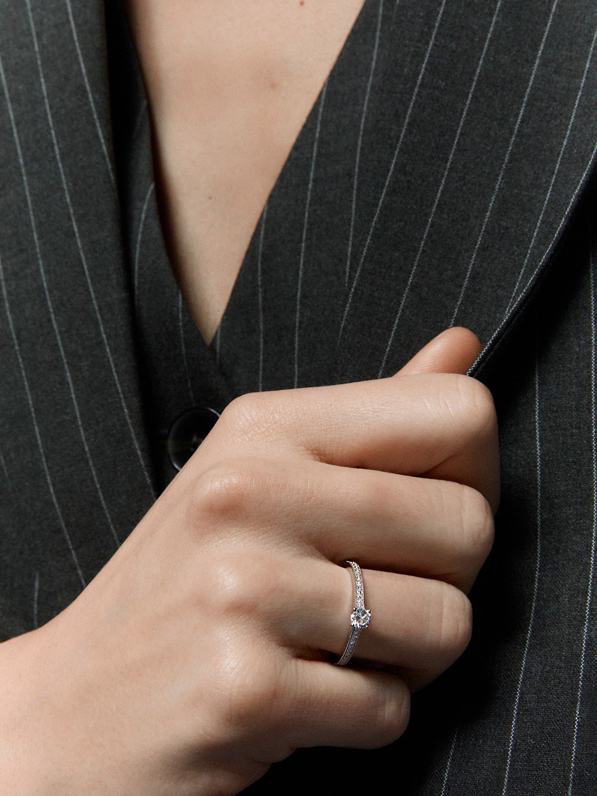 Anillo solitario de oro blanco de 18K con un diamante central en talla brillante de 0,23 cts y brazo de 29 diamantes en talla brillante con un total de 0,12 cts