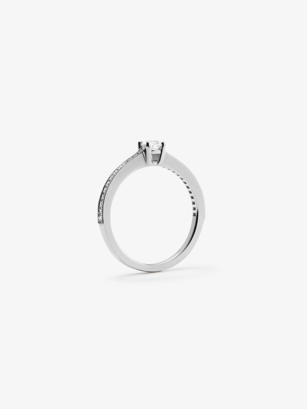 Anillo solitario de oro blanco de 18K con un diamante central en talla brillante de 0,23 cts y brazo de 29 diamantes en talla brillante con un total de 0,12 cts