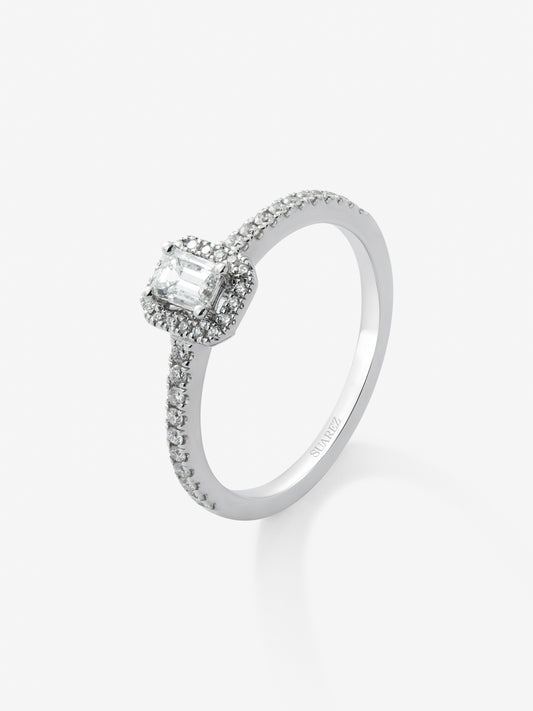 Anillo de oro blanco de 18K con diamante en talla esmeralda de 0,25 cts y orla de diamantes en talla brillante con un total de 0,19 cts