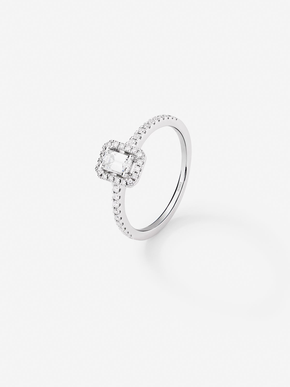 Anillo de oro blanco de 18K con diamante en talla esmeralda de 0,24 cts y orla de diamantes en talla brillante con un total de 0,17 cts