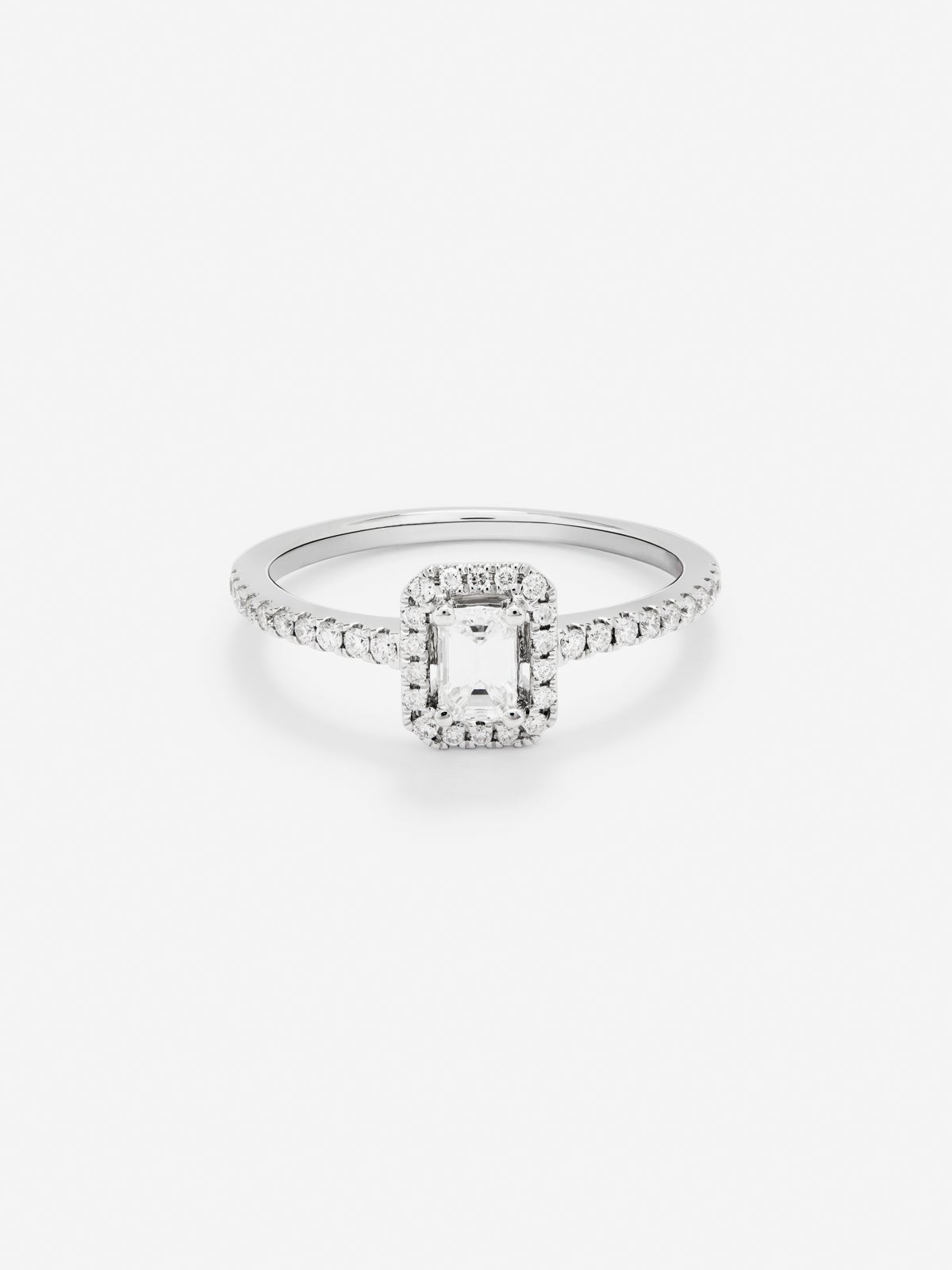 Anillo de oro blanco de 18K con diamante en talla esmeralda de 0,25 cts y orla de diamantes en talla brillante con un total de 0,19 cts