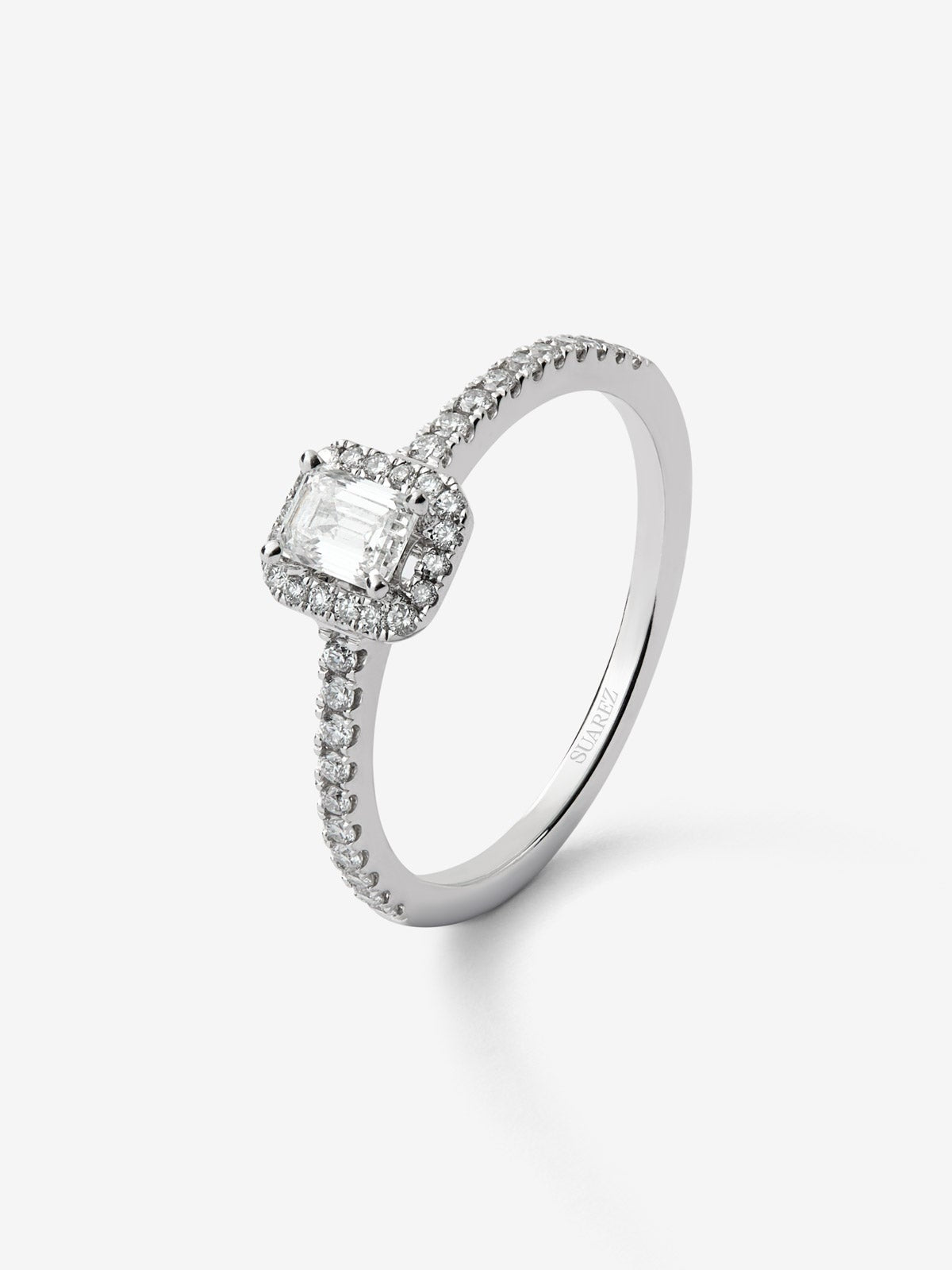 Anillo de oro blanco de 18K con diamante en talla esmeralda de 0,30 cts y orla de diamantes en talla brillante con un total de 0,19 cts