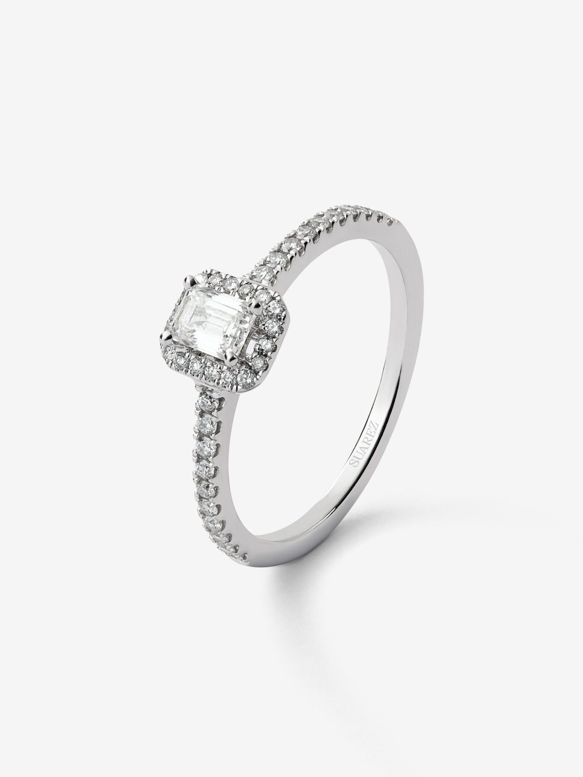 Anillo de oro blanco de 18K con diamante en talla esmeralda de 0,50 cts y orla de diamantes en talla brillante